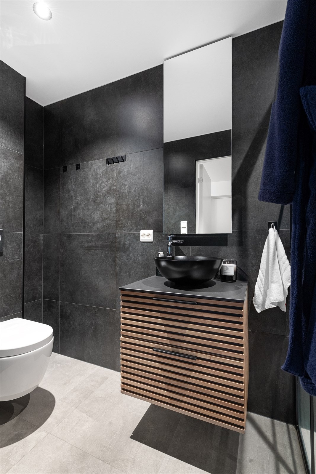 Bad i underetasjen er innredet i 2021. Flislagt gulv med gulvvarme, innredning, vegghengt toalett og dusj. Spotter i tak Galleribilde