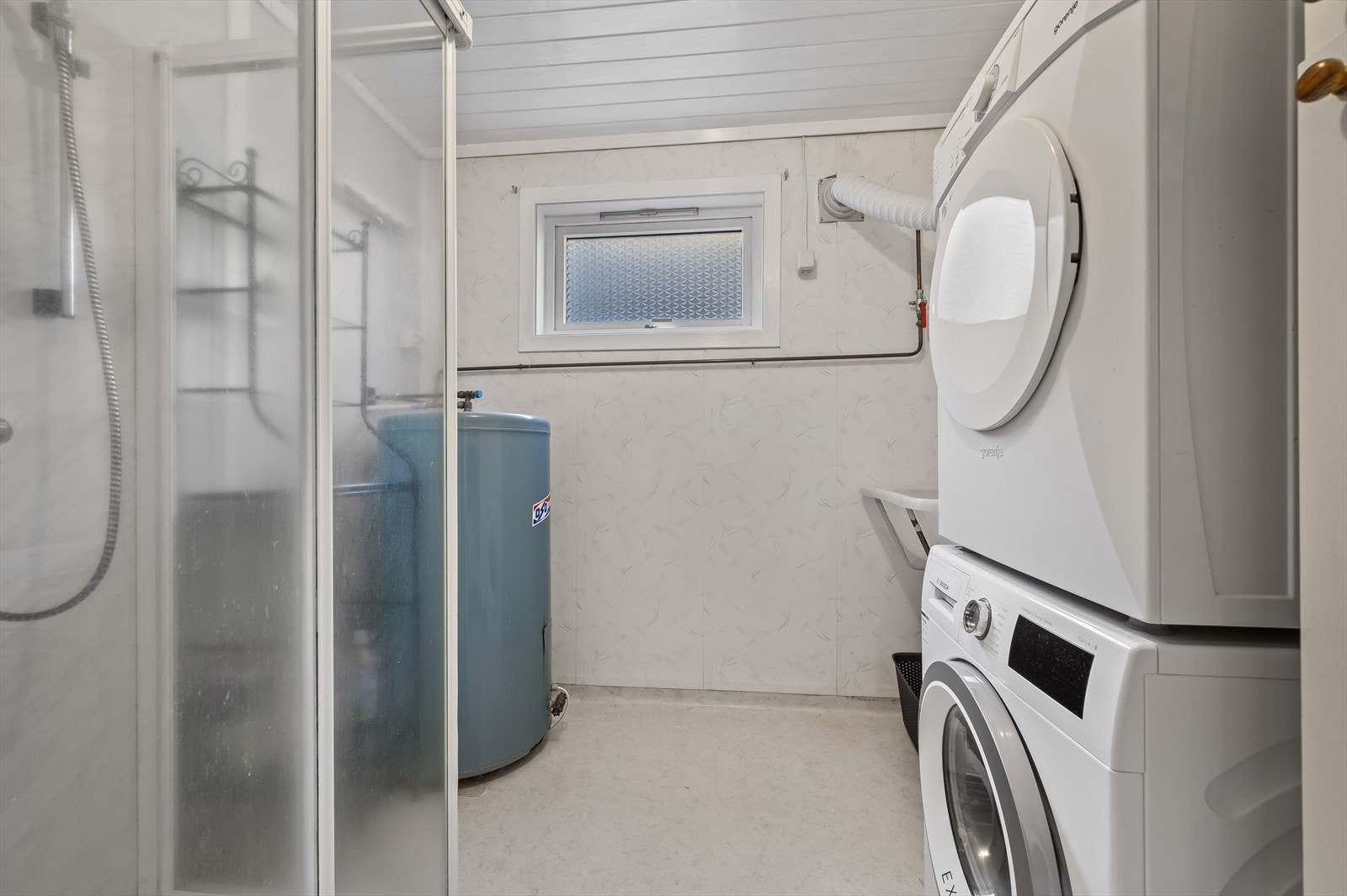 Eget vaskerom utstyrt med dusjkabinett og opplegg for vaskemaskin og tørketrommel. Galleribilde