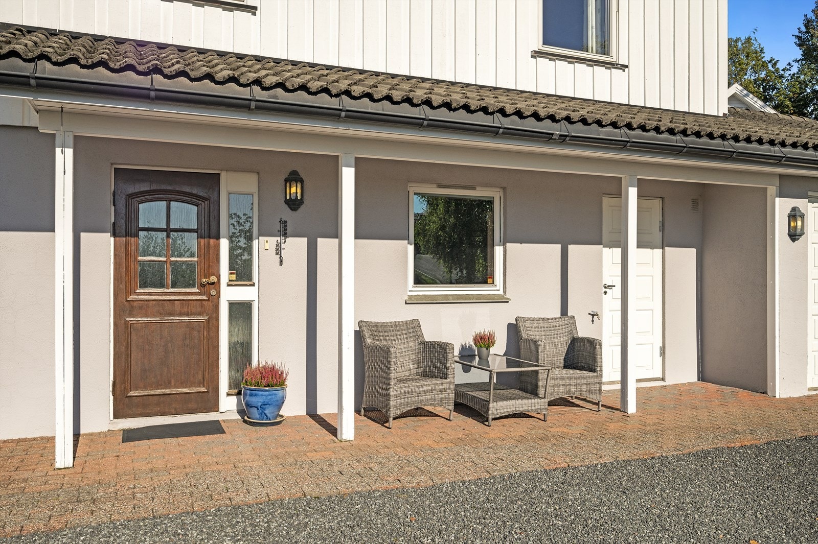 Hyggelig inngangsparti med belegningsstein og overbygg over inngangsdøren Galleribilde