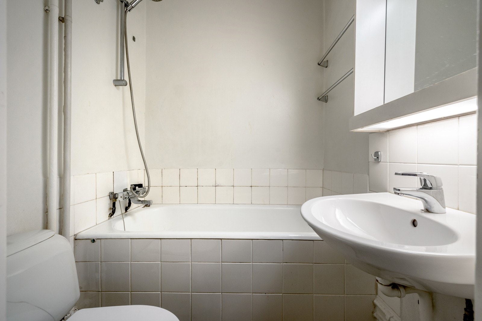 Av våtrom har leiligheten et bad med oppussingsbehov. Badet har servant, speilskap, toalett og badekar Galleribilde