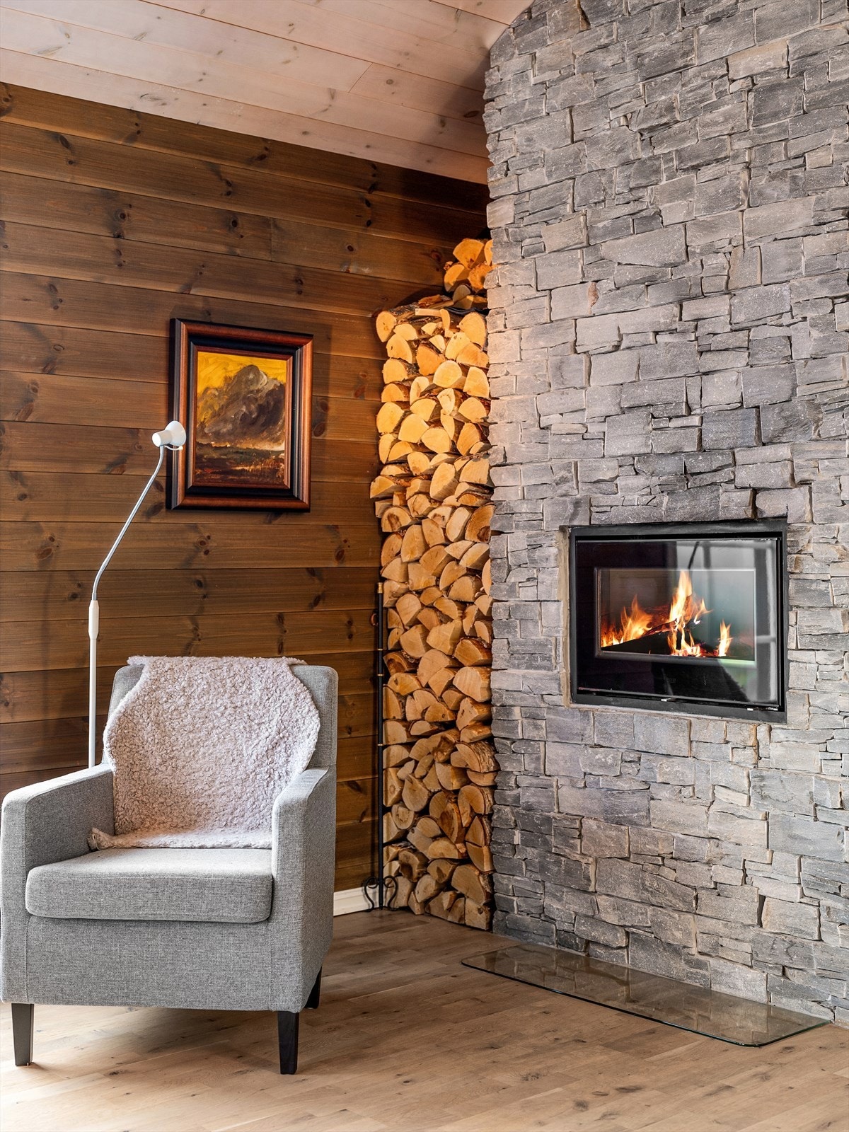 Peisen setter stemning både i stuen og på kjøkkenet. Stedbygget peis i naturstein. Praktisk og flott oppbevaring av ved. Galleribilde