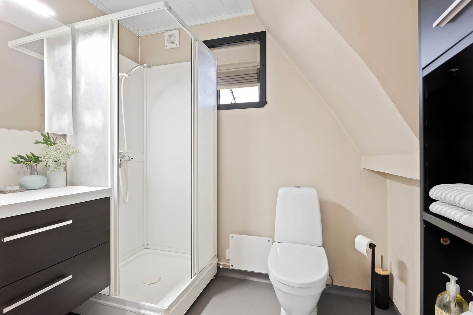 Badet har innredning med nedfelt servant og skuffer under, speil og lys over, dusjkabinett og toalett. Galleribilde