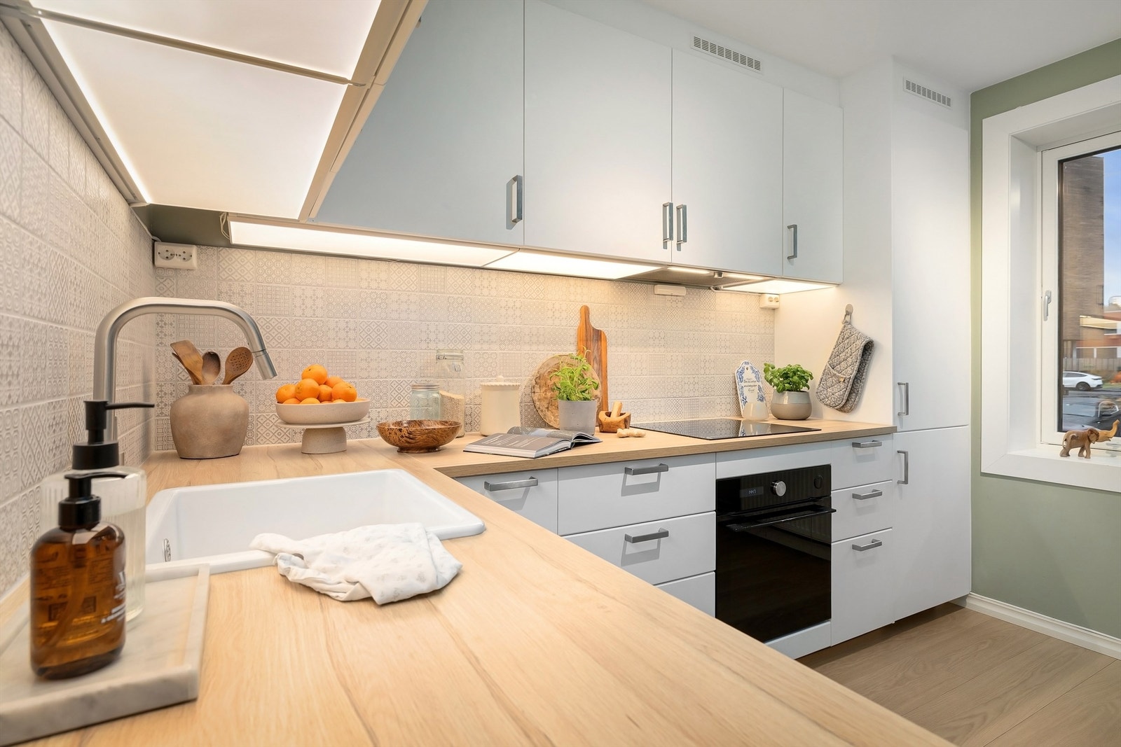 Integrert kjøleskap, oppvaskmaskin og stekeovn, samt nedfelt platetopp og ventilator med kullfilter over Galleribilde