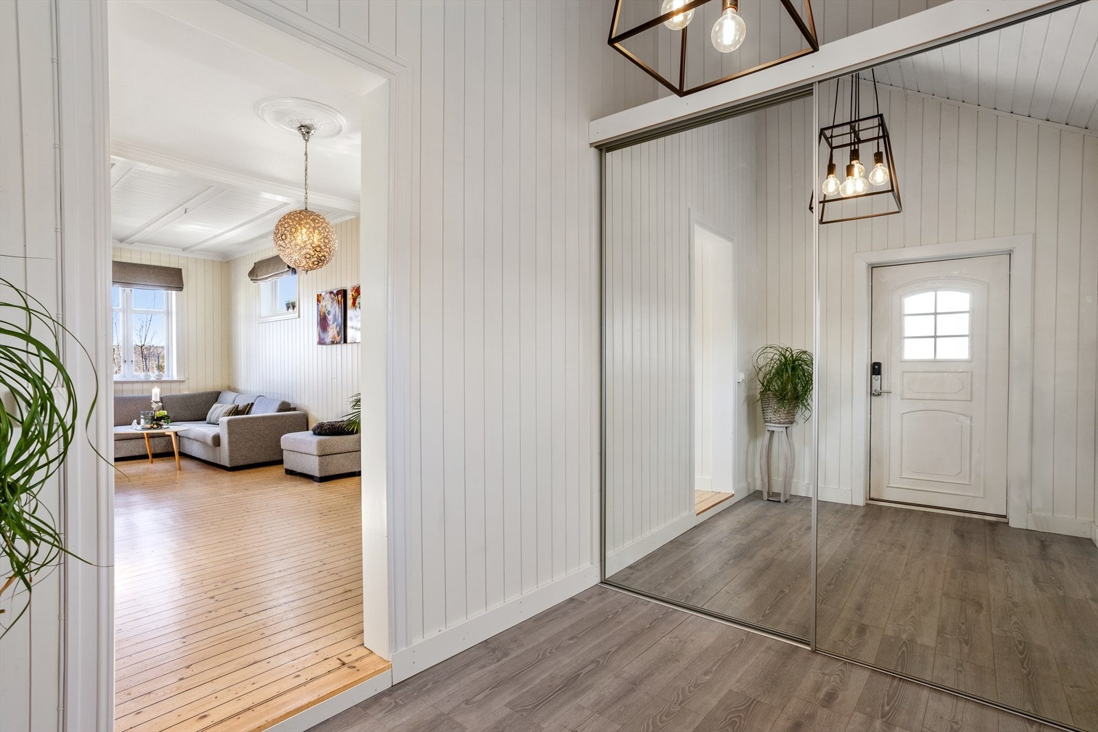 Dette moderne inngangspartiet gir et stilrent førsteinntrykk med sine delikate gråtoner og harmoniske fargevalg. Det er god plass til å ta av seg yttertøy og lignende i skyvedørsgarderobe. Galleribilde