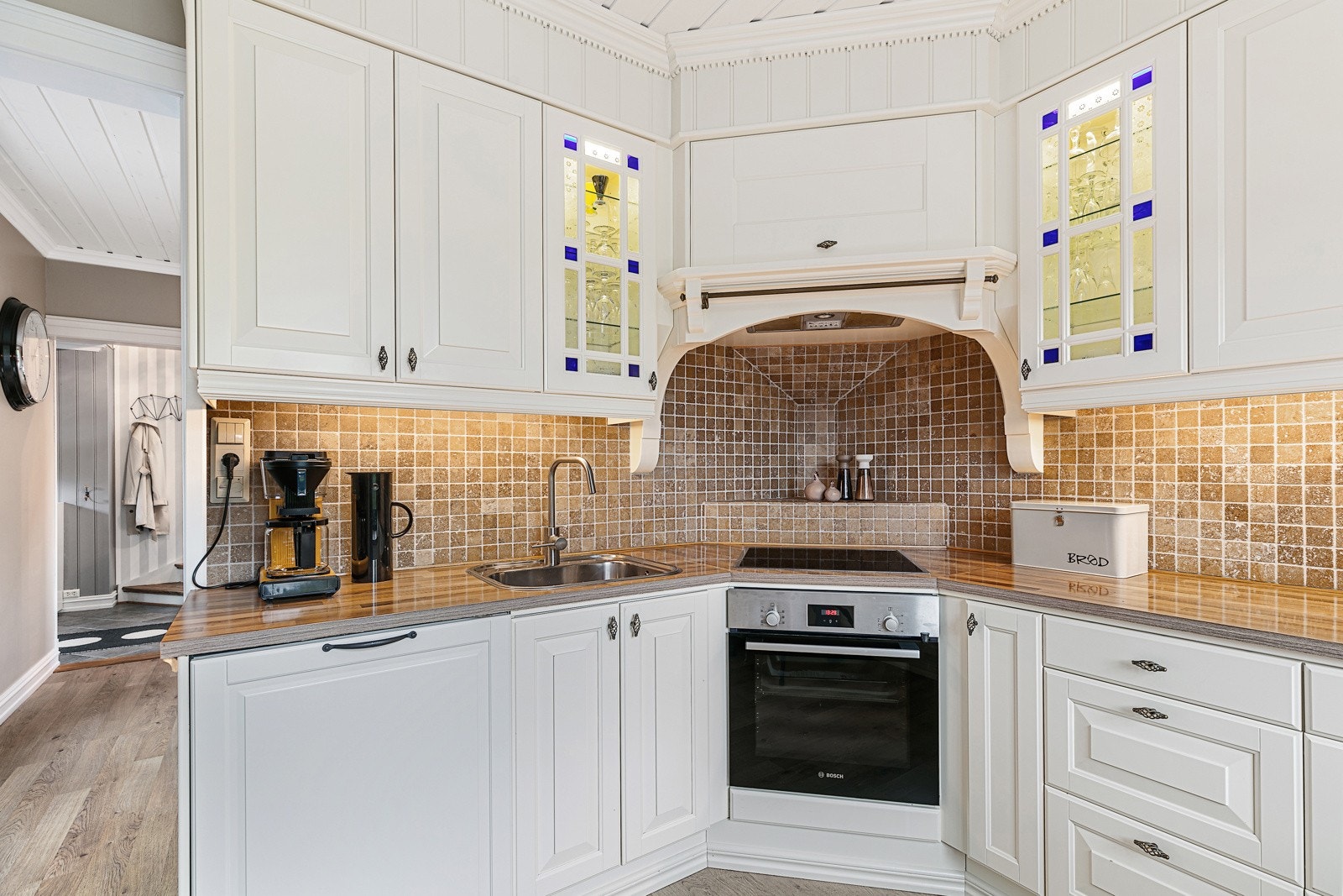 Lekkert kjøkken med fliser mellom over og underskap. Galleribilde