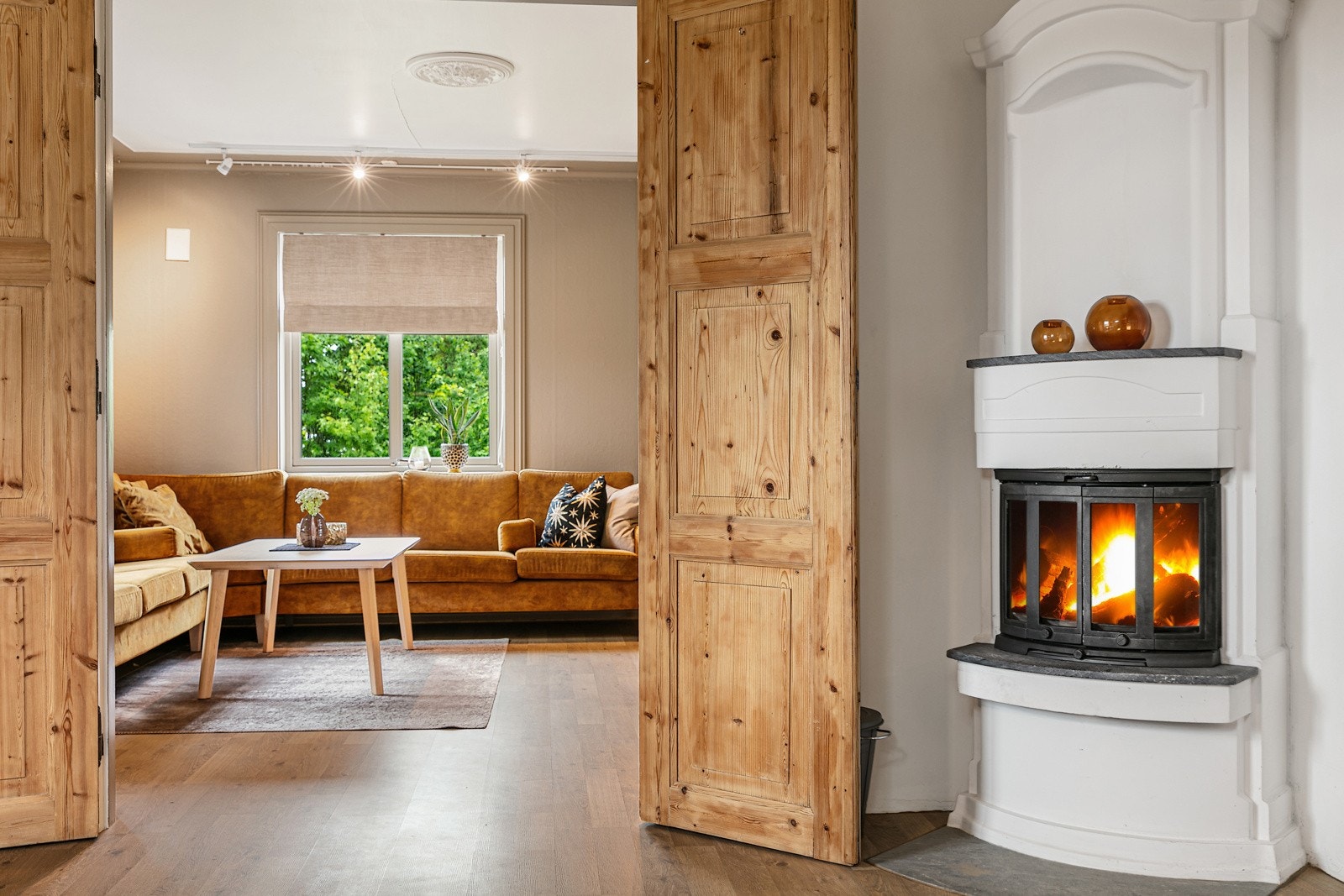 Dobble dører mellom stuen og spisestuen og flott peisovn Galleribilde