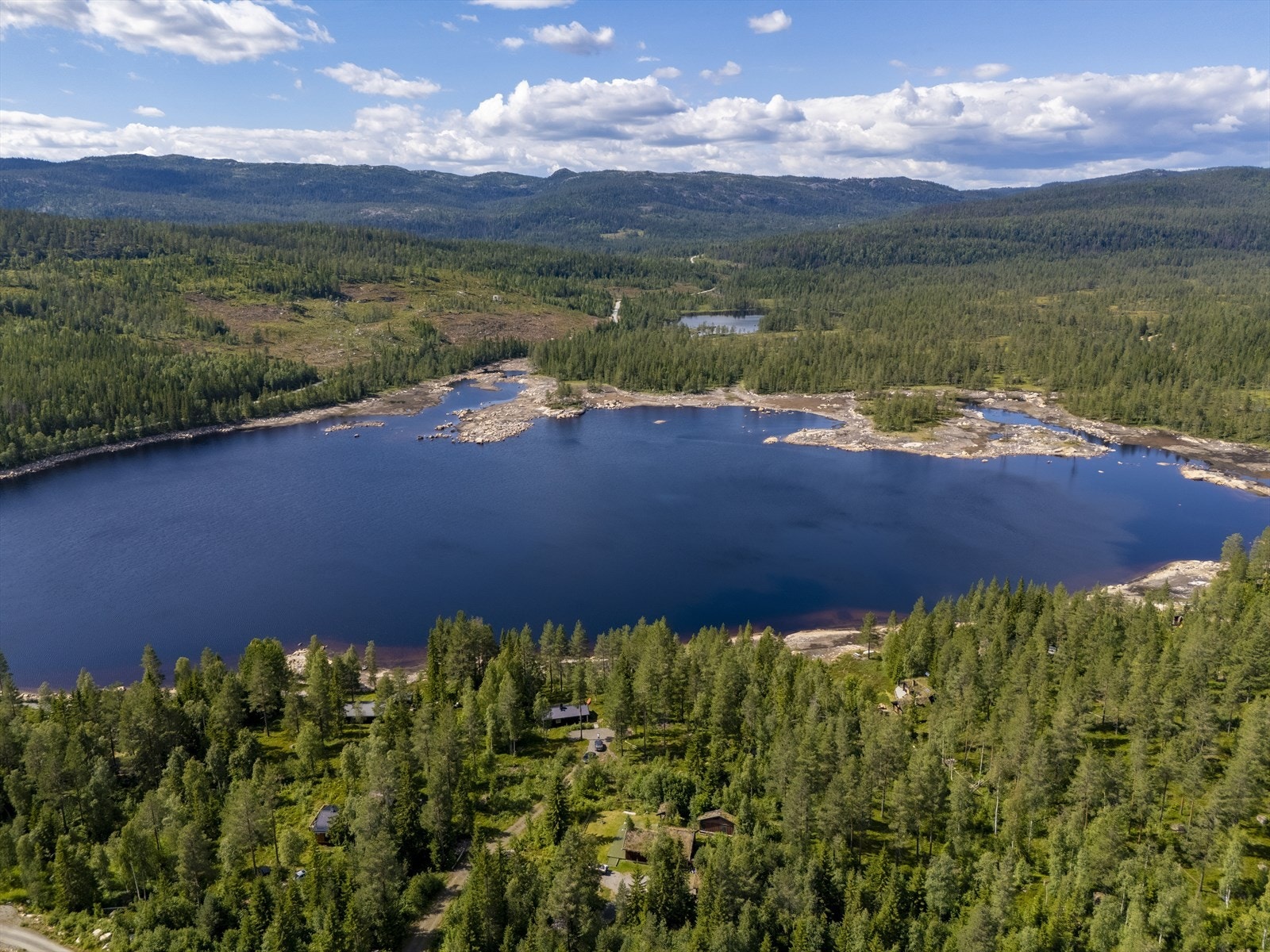 Eiendommen ligger idyllisk og skjermet til i forhold til nabohyttene, og har fantastisk utsikt over vannet. Galleribilde