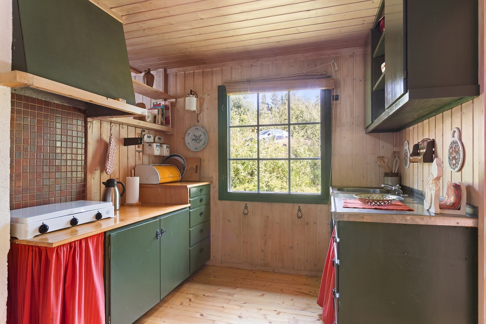 Kjøkkeninnredningen er fra byggeåret og består av glatte, malte fronter samt benkeplate med stålvask og kum. Galleribilde