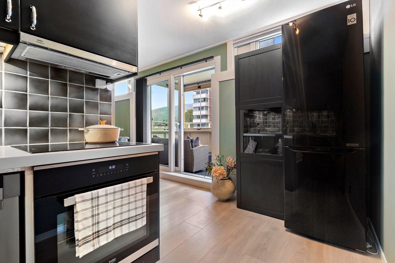 Pen kjøkkeninnredning med med glatte sorte fronter og benkeplate av laminat. Galleribilde