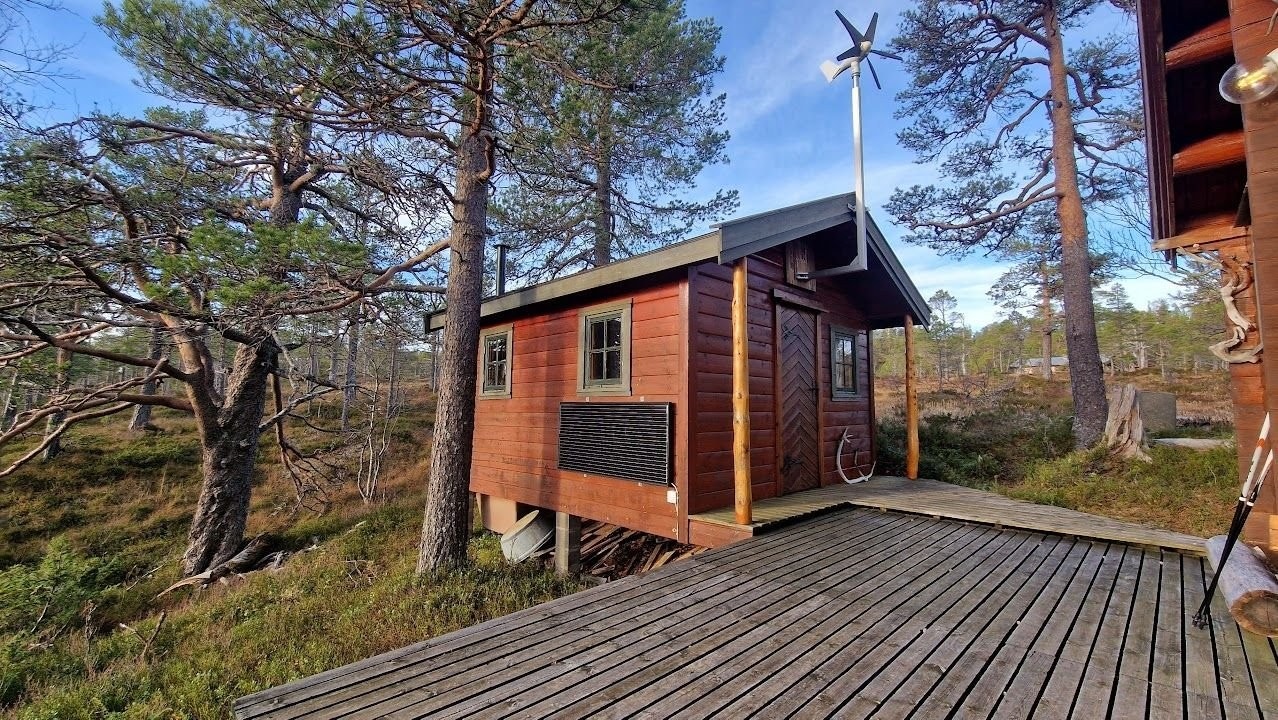 Uthus med vindgenerator og solcellepanel Galleribilde