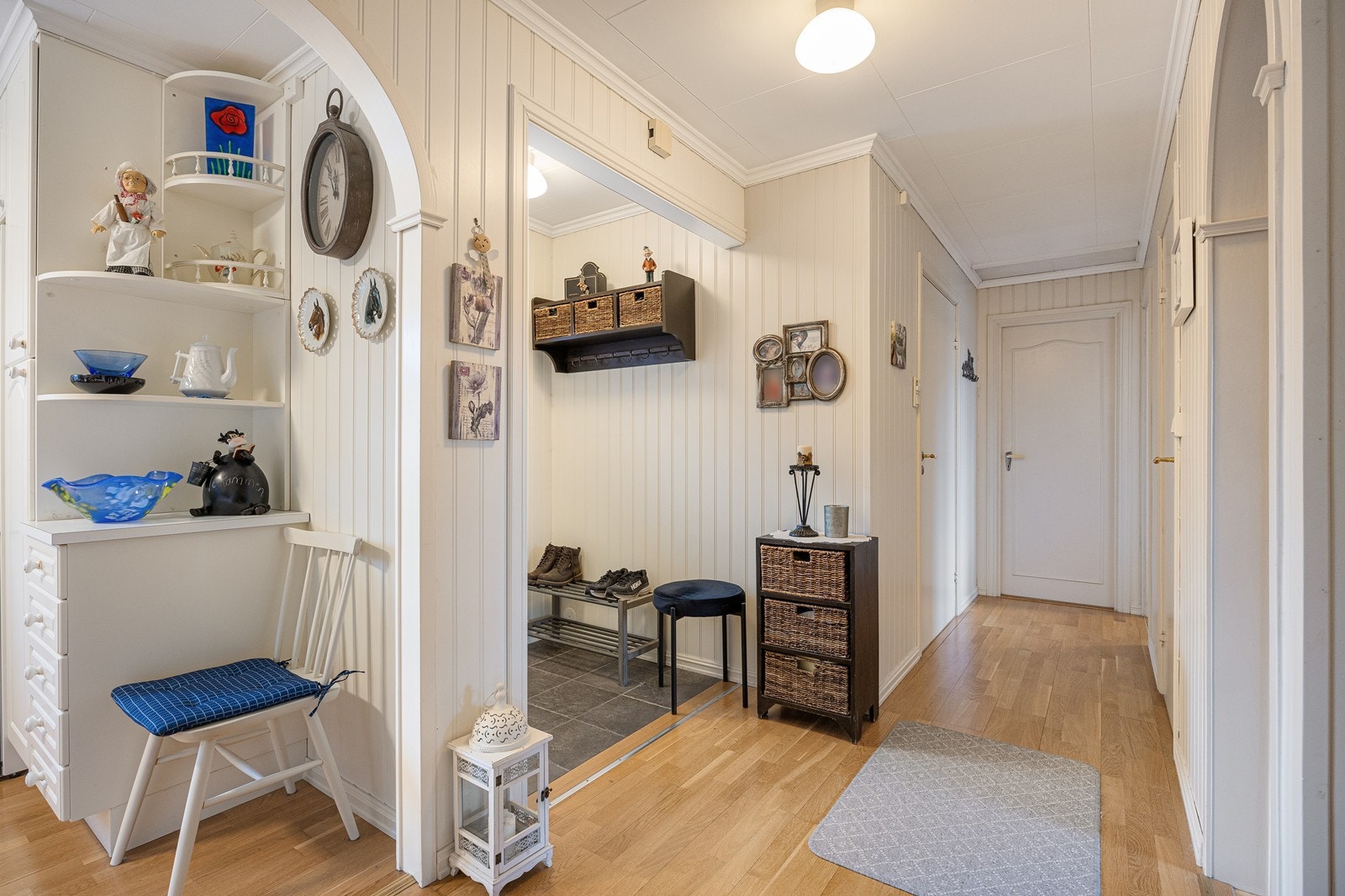 Det er plass til å henge fra seg yttertøyet, og entreen er direkte tilknyttet en gang med parkett på gulvet. Boligen har også egen inngang til kjelleretasjen. Galleribilde