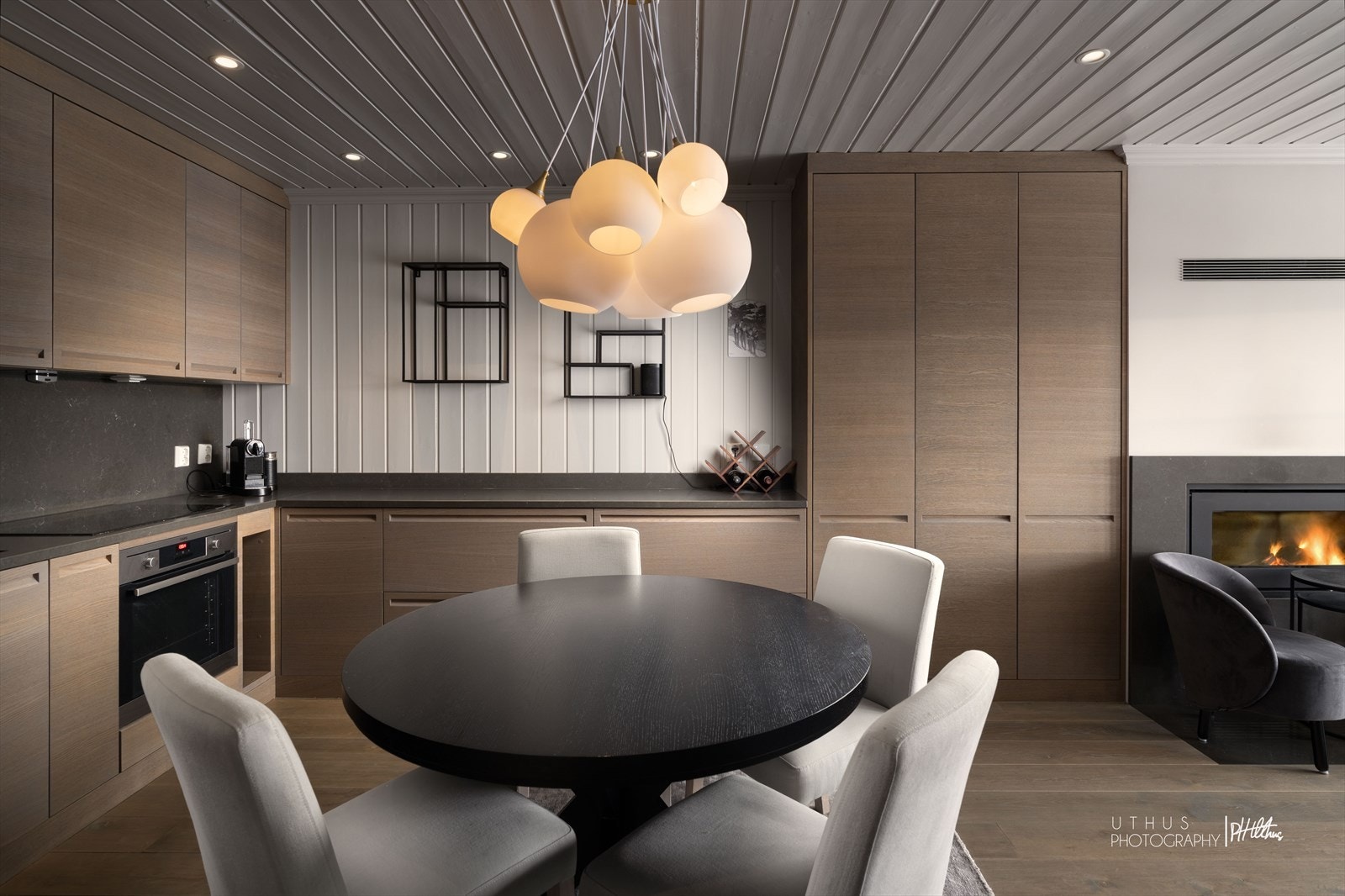 Kjøkkenet har slette eike-laminerte fronter ogen mørkfarget benkeplate i stein. Galleribilde