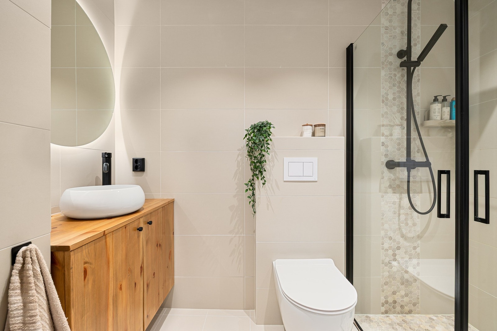 Leiligheten har et stort bad med lyse flis og varmekabler i gulvet. Galleribilde