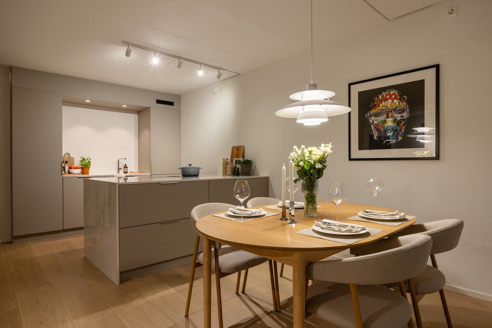 Kjøkkeninnredning med glatte fronter og keramikk benkeplater. Galleribilde