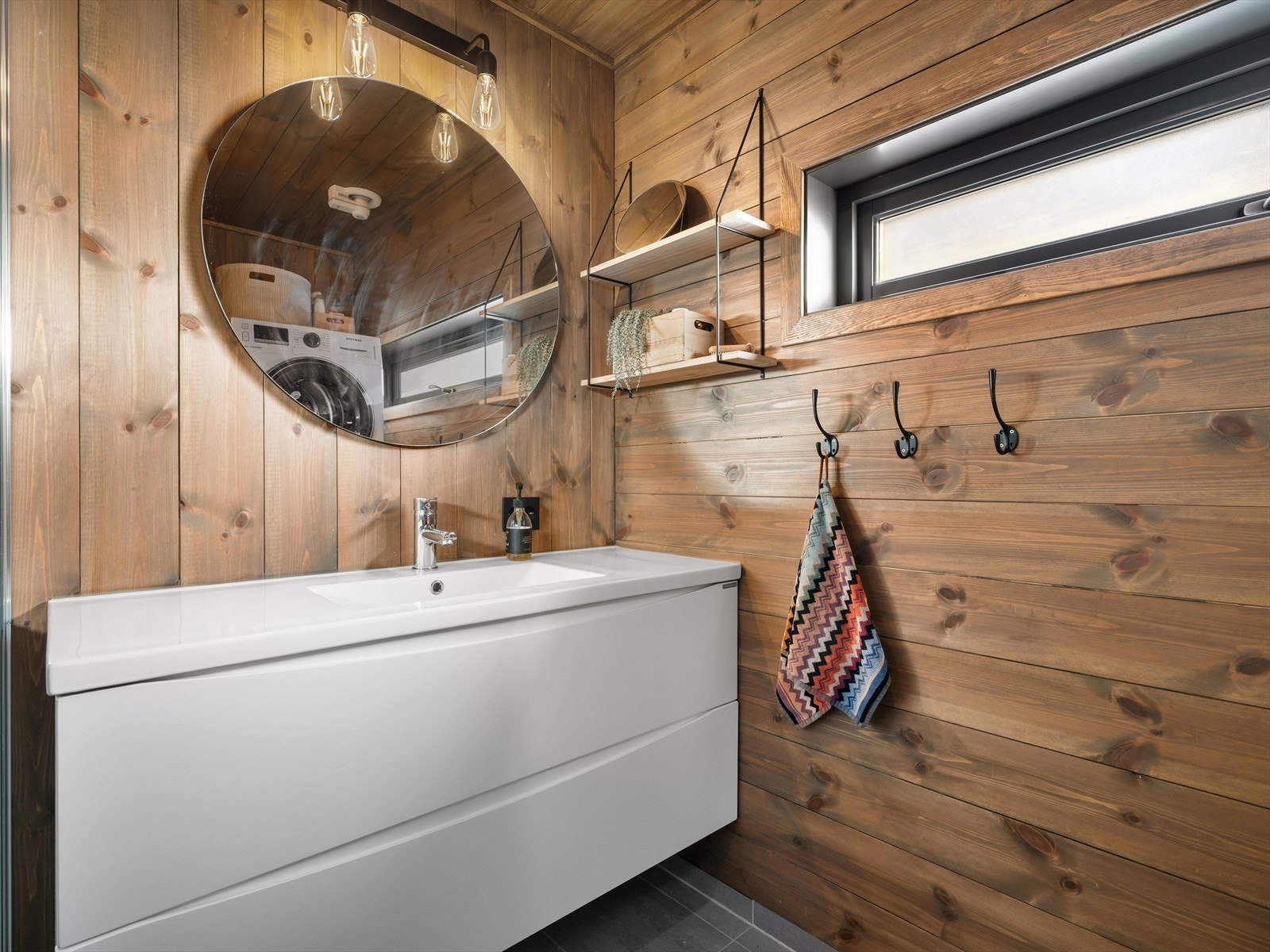 Lekkert baderom med fliser og varme i gulv. Stor servant for oppbevaring. Fine, nøytrale farger som gjør det enkelt å tilføre sitt eget preg med personlig interiør. Galleribilde