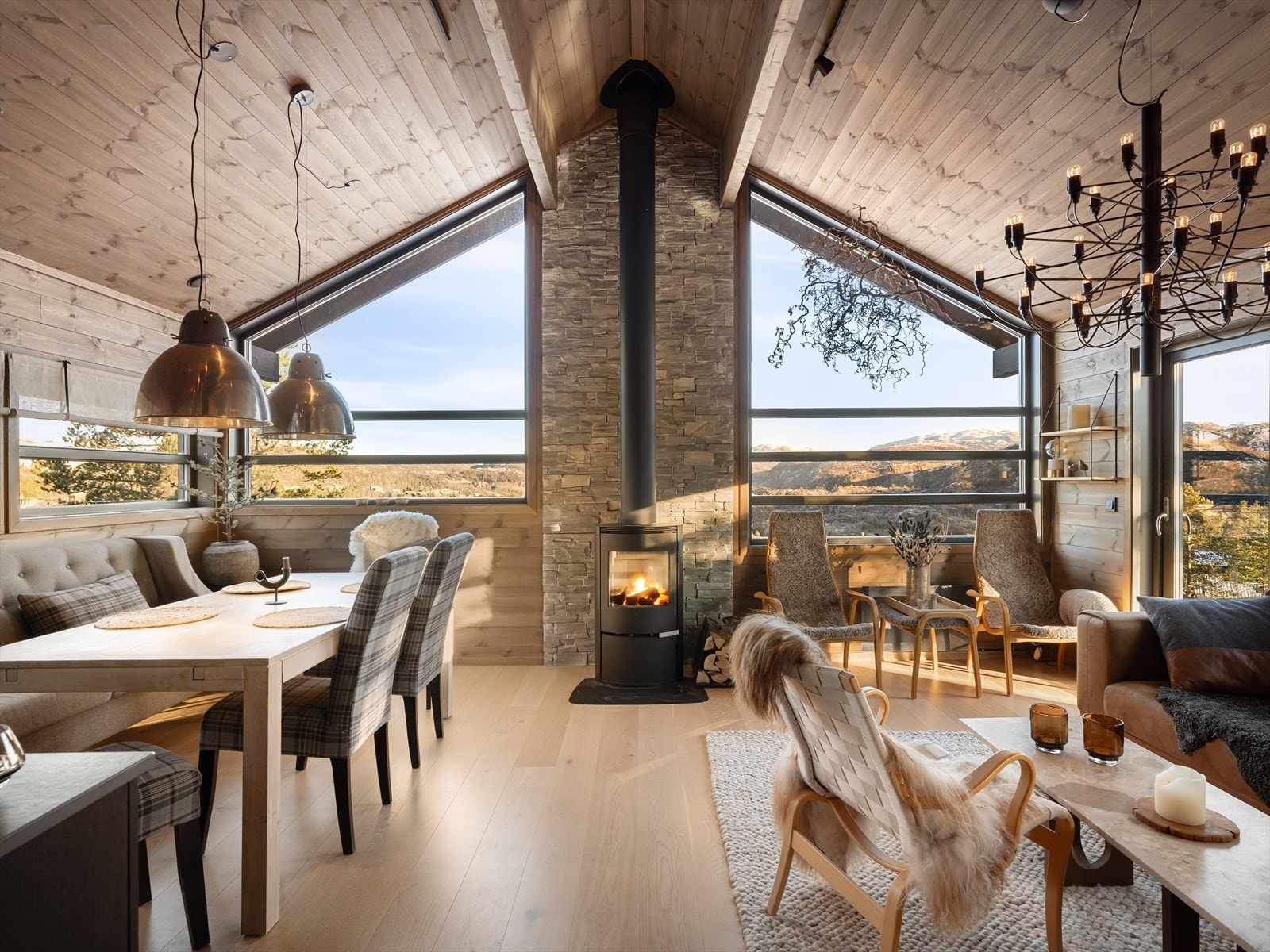 Stuen har følelsen av å sitte i naturen. God takhøyde og smart vindusbruk for fint lys. Her er det delikat og lunt. Lekker peis med naturstein bak. Galleribilde