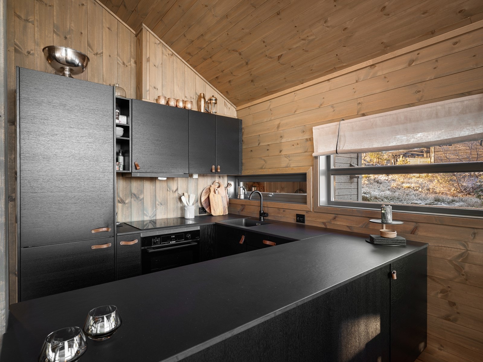 Norema kjøkkenet med en elegant steinbenkeplate, integrerte hvitevarer av høy kvalitet og ekstra oppbevaringsplass i sokkelen. Galleribilde