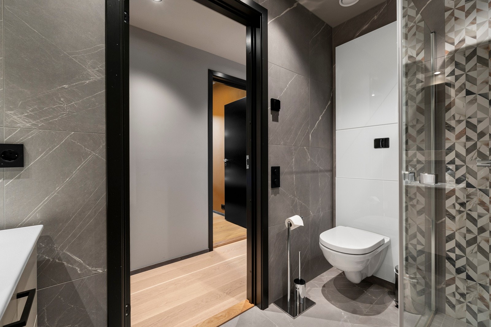 Badet er svært delikat med lekre fliser på gulv og vegg, downlights i himlingen, dusjhjørne med glassdører og regnfallsdusj, samt vegghengt wc. Galleribilde