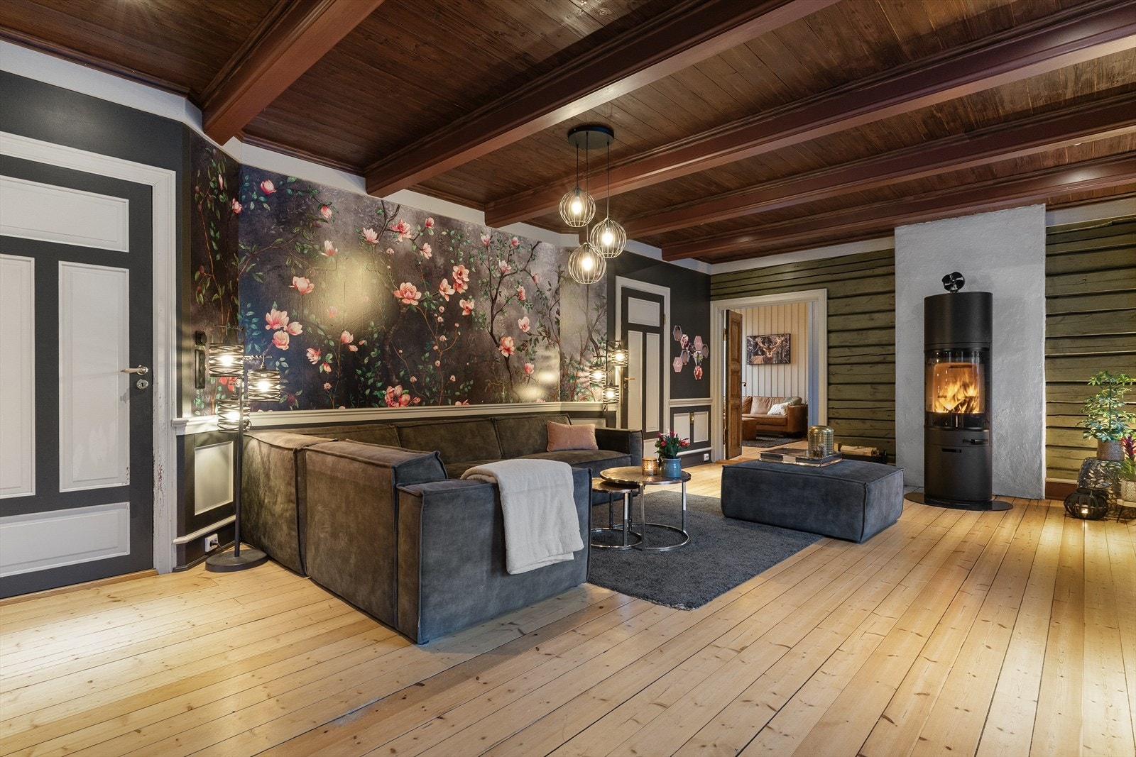 På den ene kortveggen er det en lekker, høy peisovn som kan nytes fra hele rommet. Galleribilde