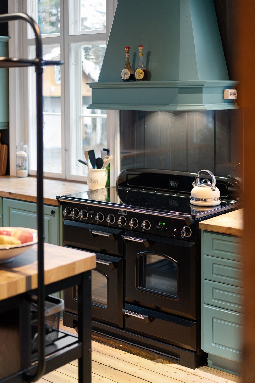 Komfyren er en Falcon Classic Delux 110, en elegant og tidløs komfyr som er utstyrt med fem kokesoner på induksjonstopp, to stekeovner (en multifunksjonsovn og en varmluftsovn), separat, uttrekkbar grill og en heveskuff. Galleribilde