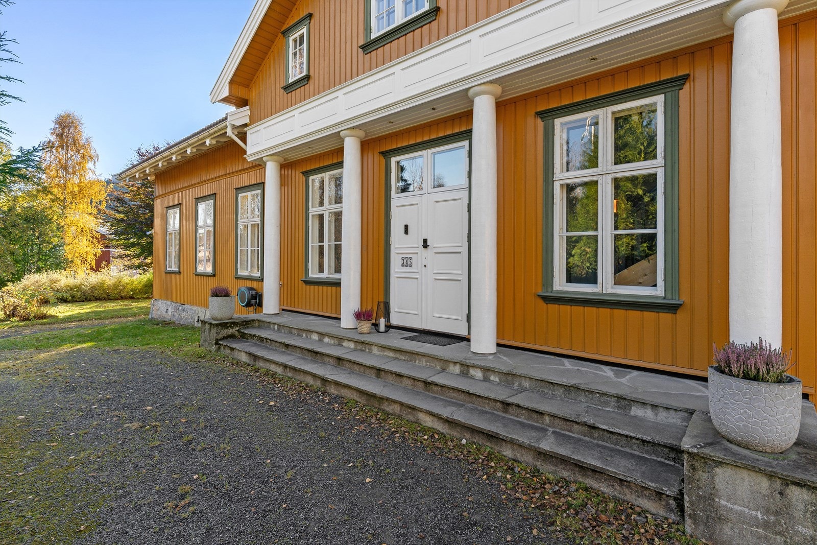 Hovedinngangen til boligen har et staslig utseende med fire søyler og bred trapp opp til dobbel inngangsdør. Galleribilde