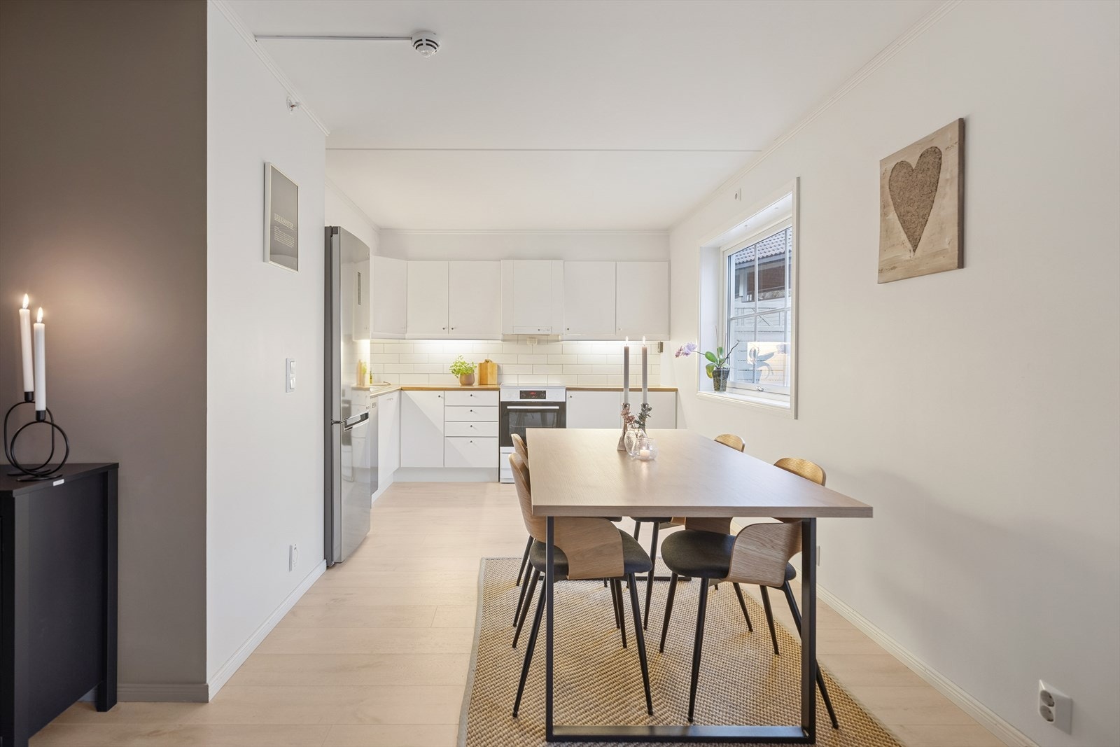 Stue og kjøkken med enstavs laminat og lyse malte veggoverflater. Galleribilde