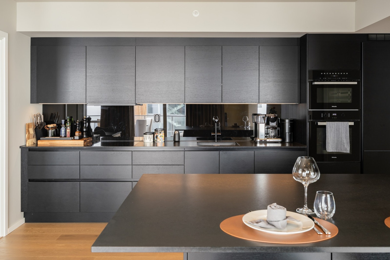 Stort eksklusivt kjøkken fra HTH med integrerte hvitevarer fra Miele, som stekeovn, dampovn, kombiskap, oppvaskmaskin, induksjonstopp, mikrobølgeovn og vinskap. Galleribilde
