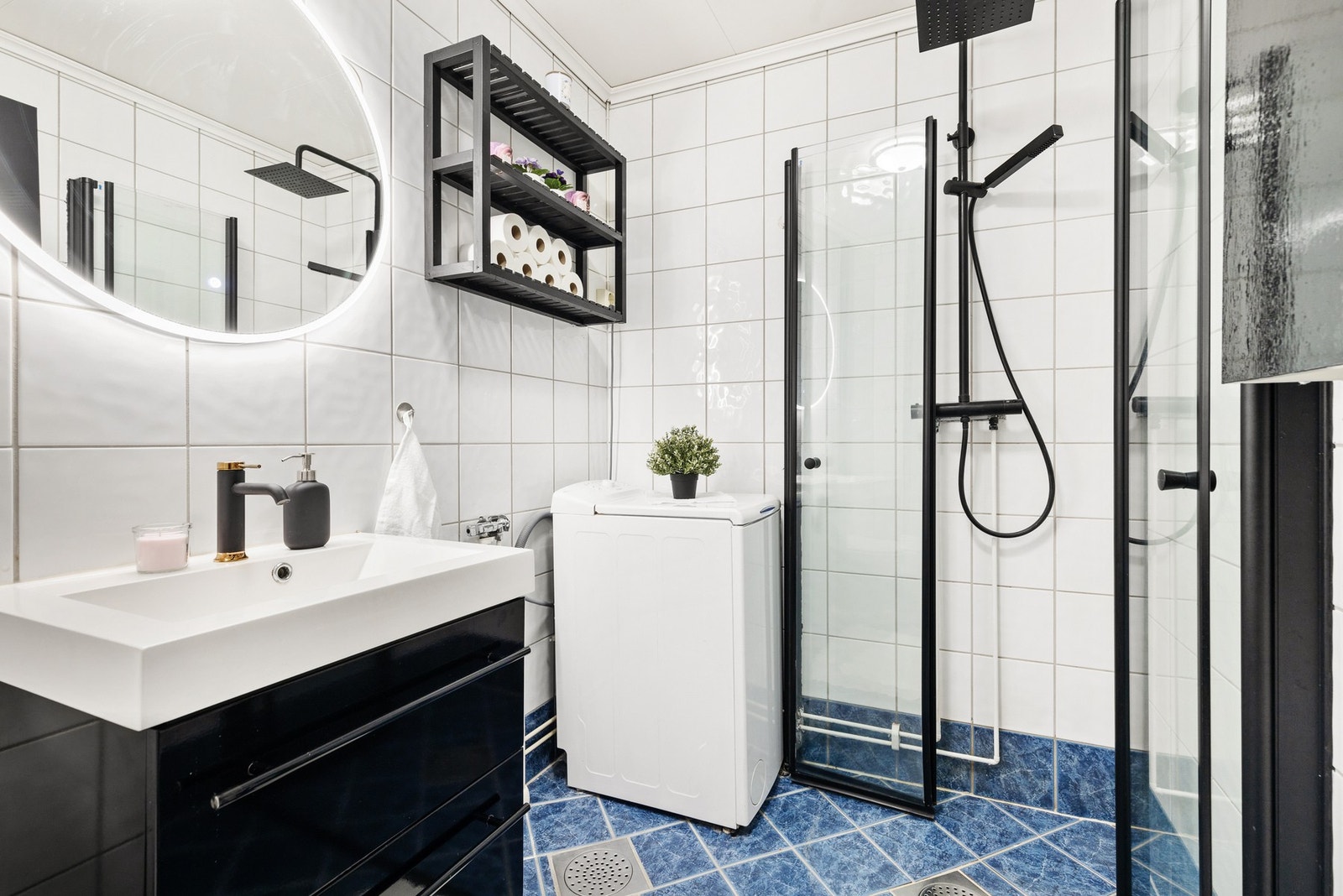 Badet er utstyrt med dusjhjørne med innfellbare dører og opplegg for vaskemaskin Galleribilde