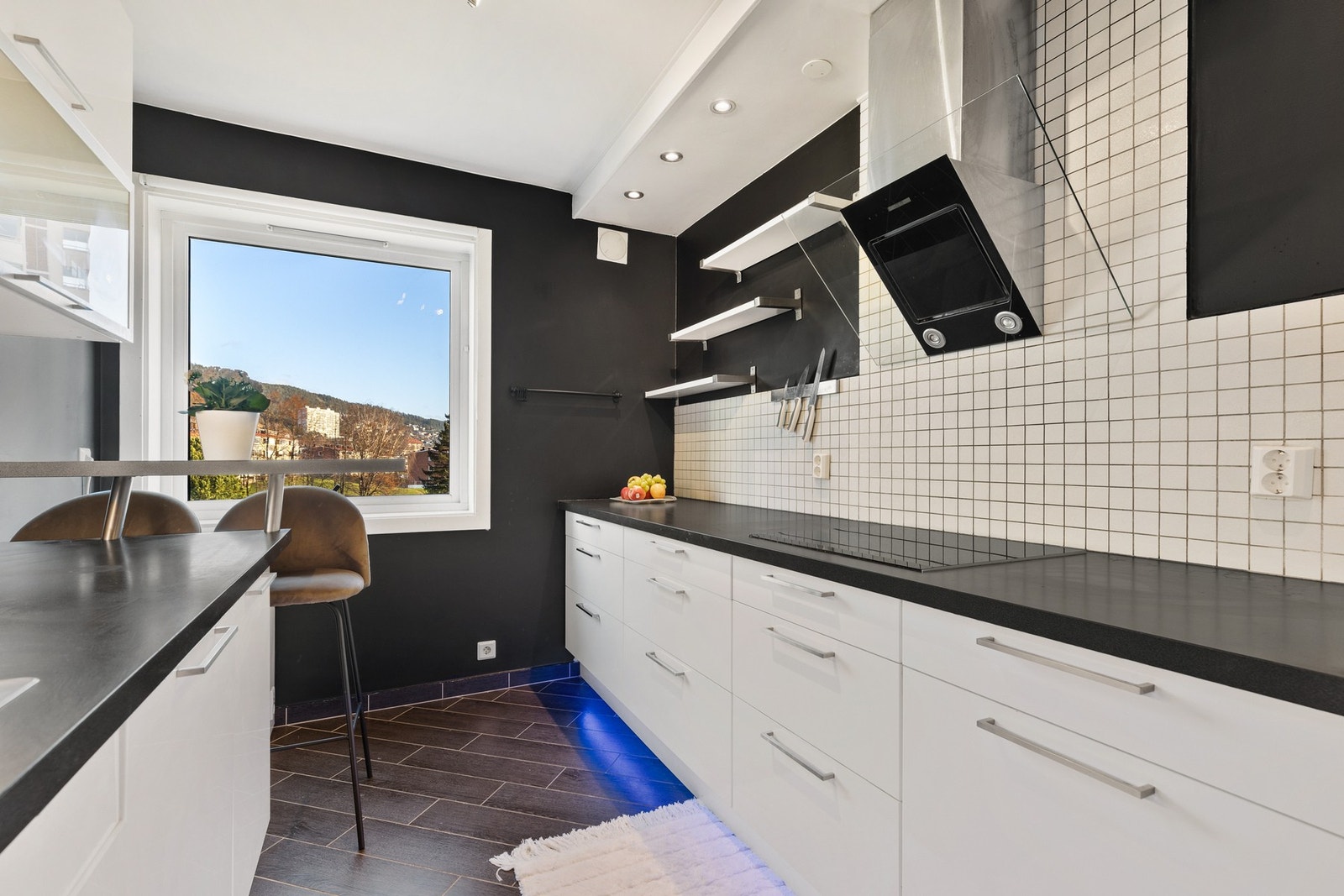 Moderne kjøkkeninnredning med integrerte hvitevarer, herunder kjøl/fryseskap, oppvaskmaskin, stekeovn, platetopp og mikro Galleribilde