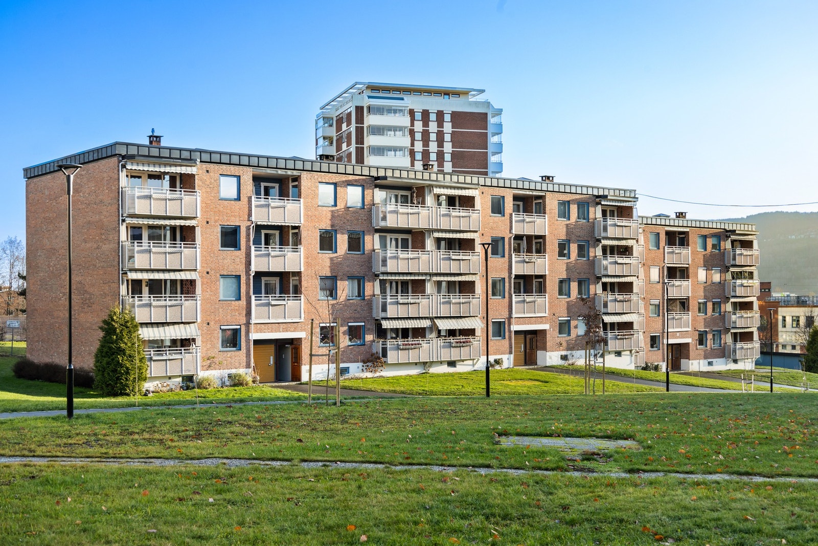 Tomten er pent opparbeidet med asfalterte internstier, plenarealer og diverse beplantning Galleribilde