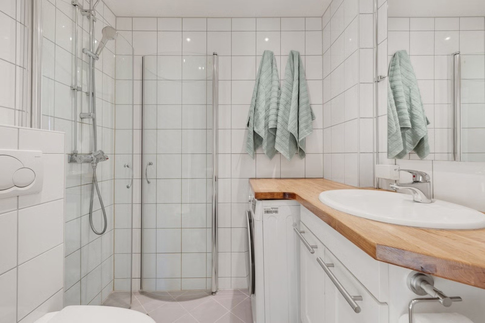 Badet er innredet med vegghengt toalett, dusjhjørnet med svingbare dører, servant med skapinnredning. Galleribilde