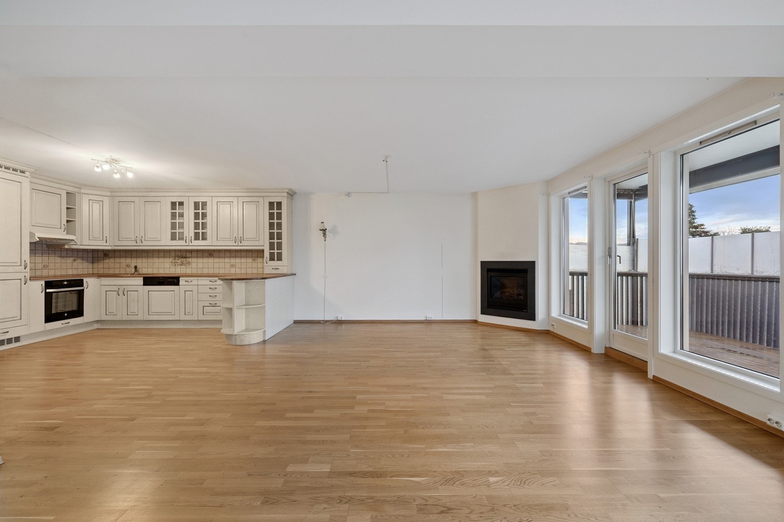 Åpen løsning mellom stue og kjøkken. Gasspeis i hjørnet av spisestuen Galleribilde