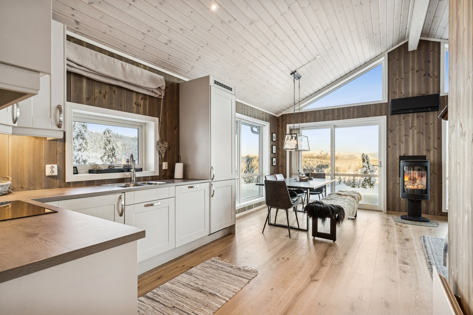 Åpen kjøkken- og spiseplass med store vinduer som gir herlig kontakt med naturen utenfor. Galleribilde