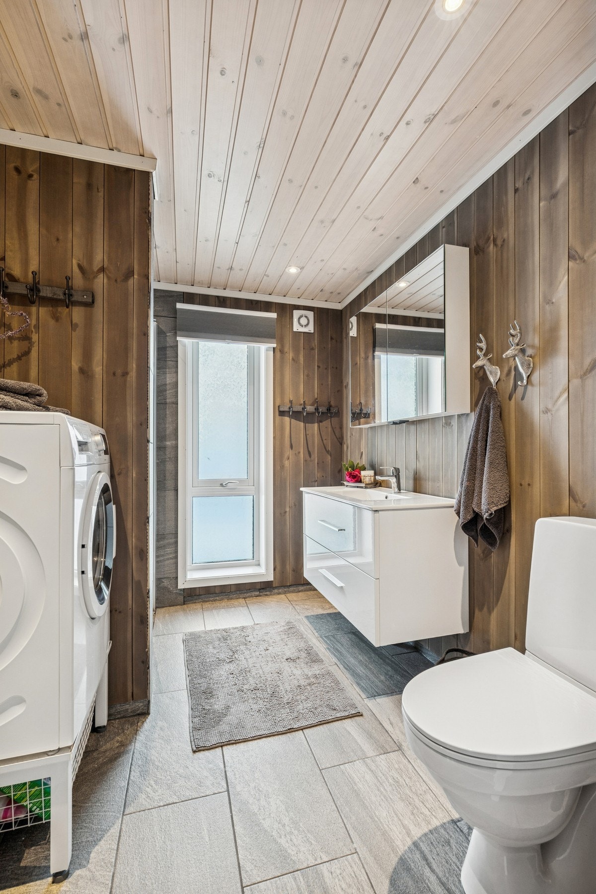 Baderommet er utstyrt med toalett, servantinnredning, dusj og opplegg for vaskemaskin. Galleribilde