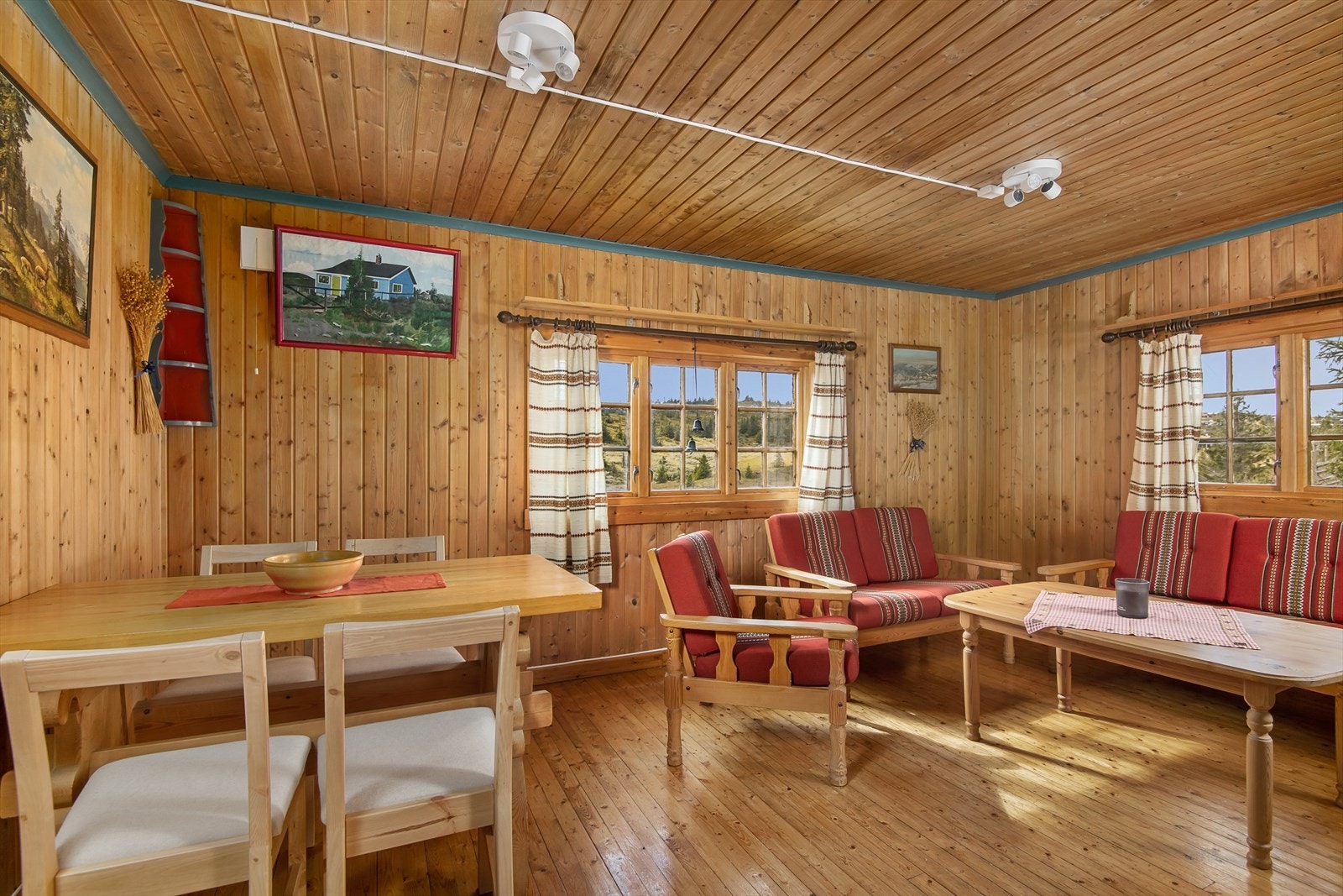 Lys og trivelig stue i tradisjonell hyttestil med tregulv og paneler. Galleribilde