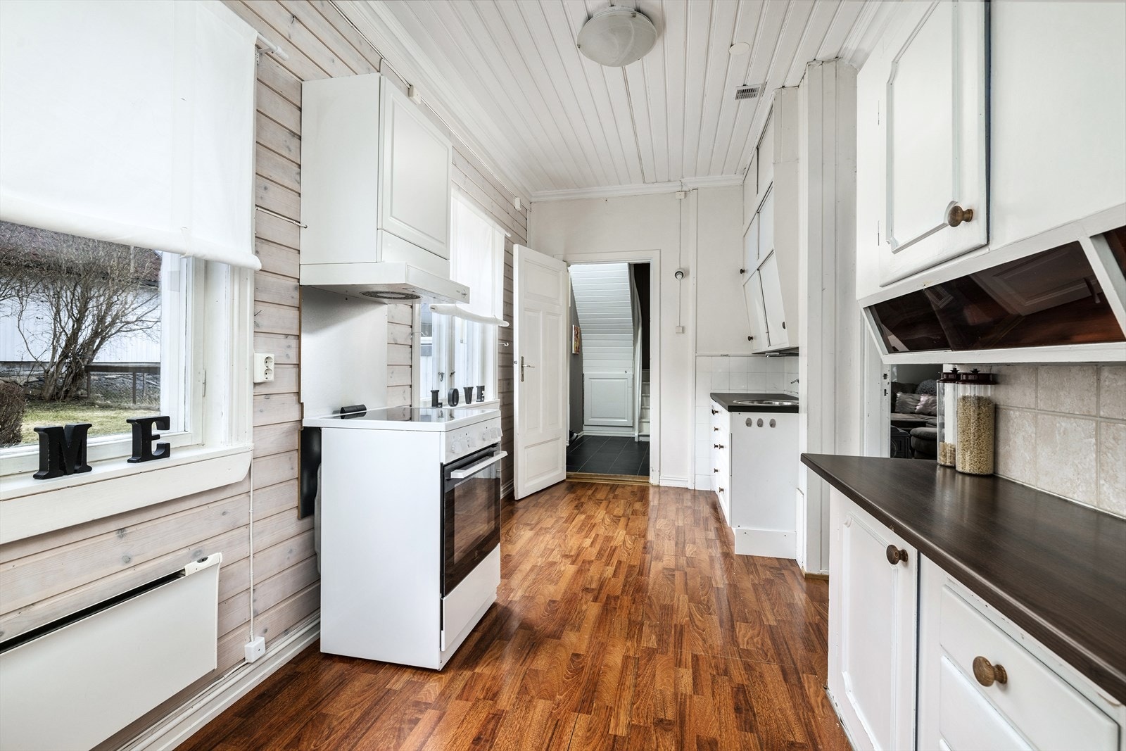 Kjøkken med eldre innredning med profilerte fronter. Frittstående hvitevarer. Galleribilde