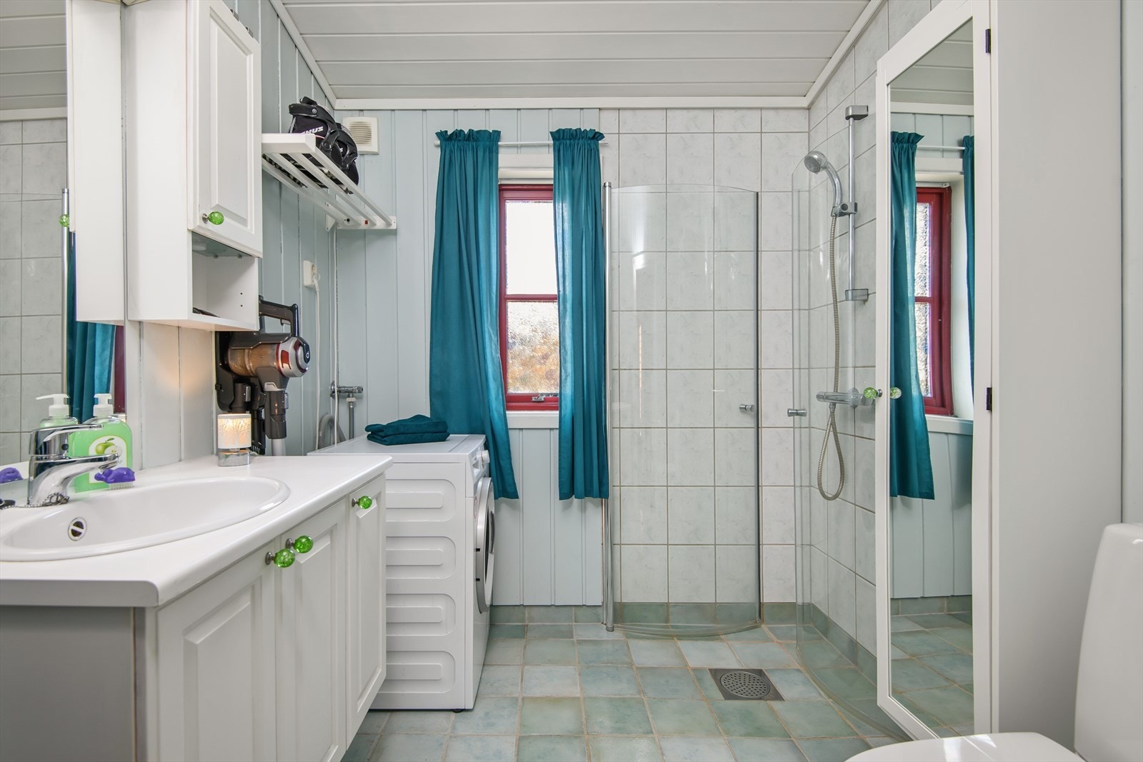 Tidløst og funksjonelt bad/wc med dusjkabinett, servantinnredning og opplegg for vaskemaskin. Galleribilde