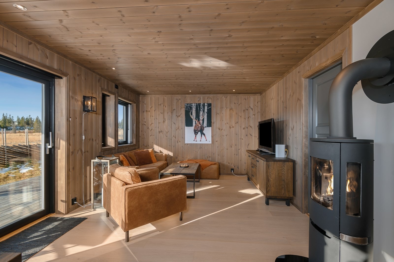 En peisovn er fint plassert i rommet og sørger for ekstra god varme på de kalde dagene. Galleribilde