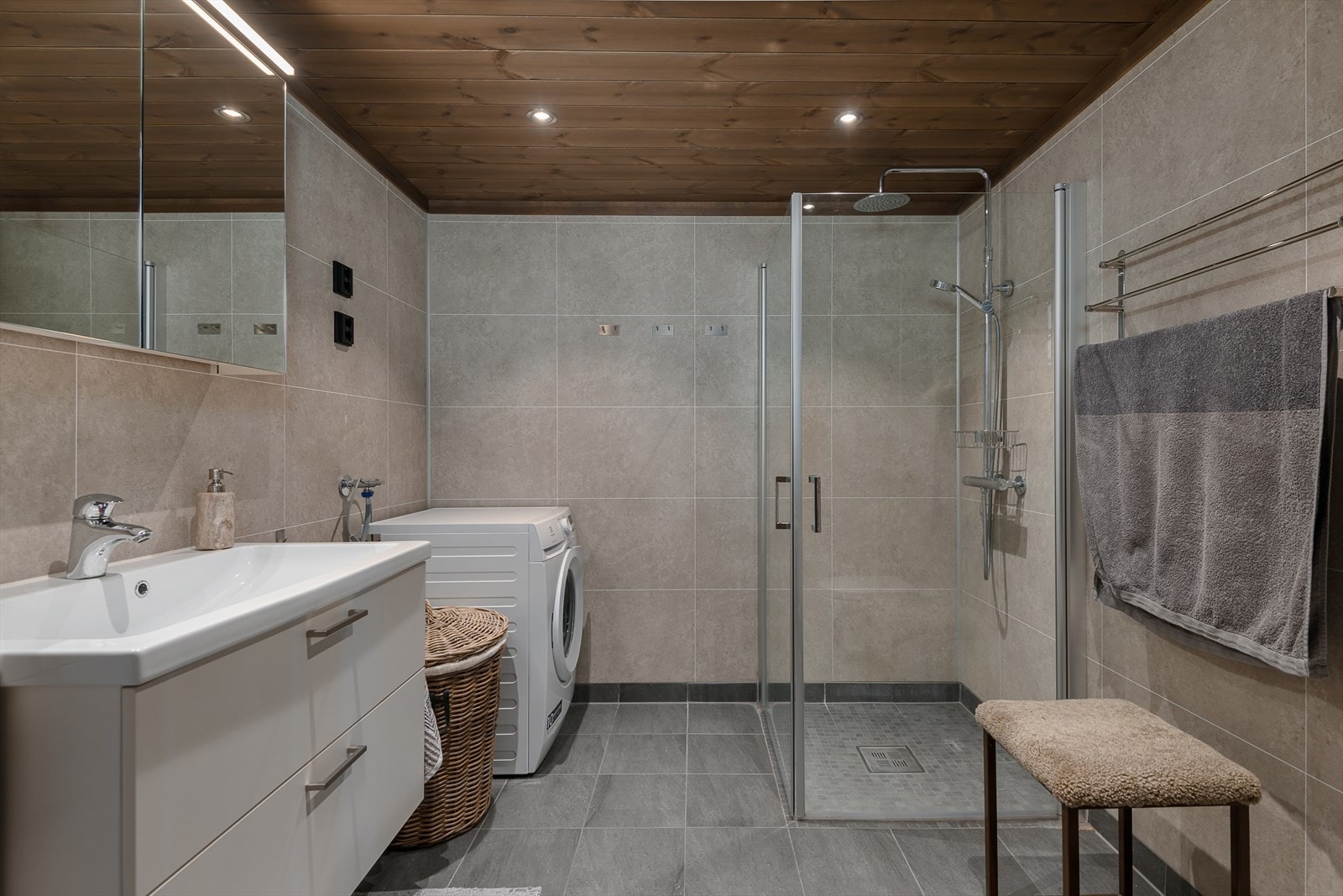 Lekkert og tidølst bad/w med flislagte vegger og gulv. Dusj med glassdører, wc og opplegg for vaskemaskin. Galleribilde