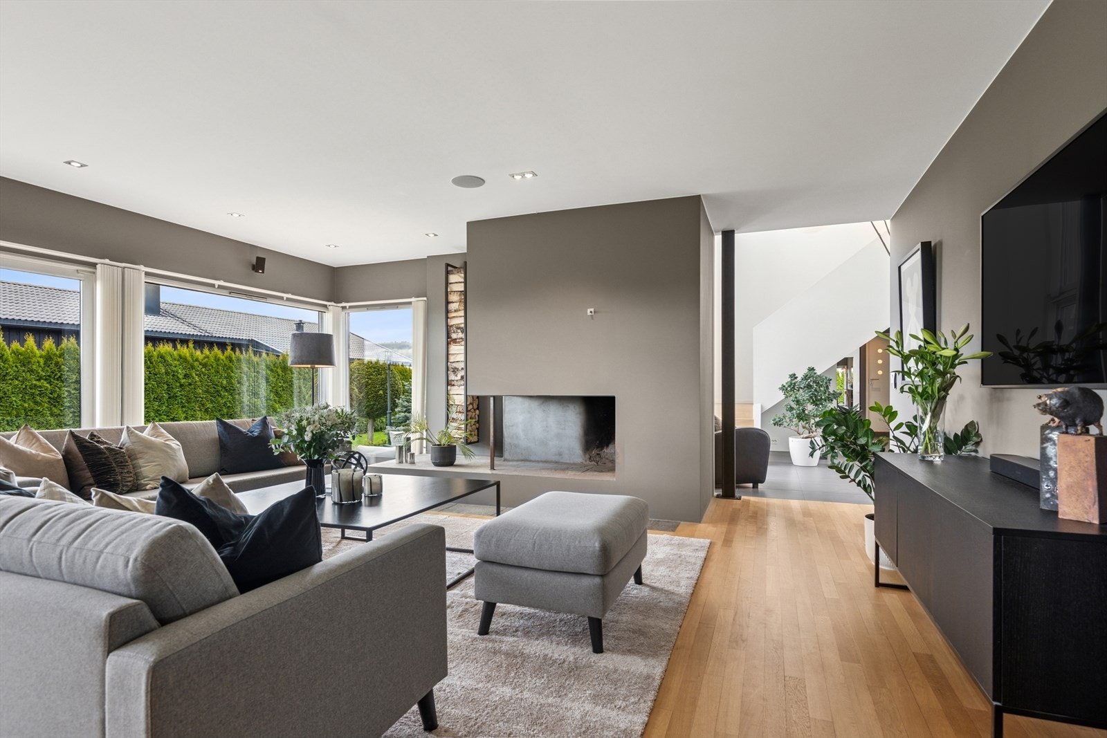 Stuen nyter godt av de store vinduflatene som gir rikelig med dagslys og herlig utsyn til hagen Galleribilde