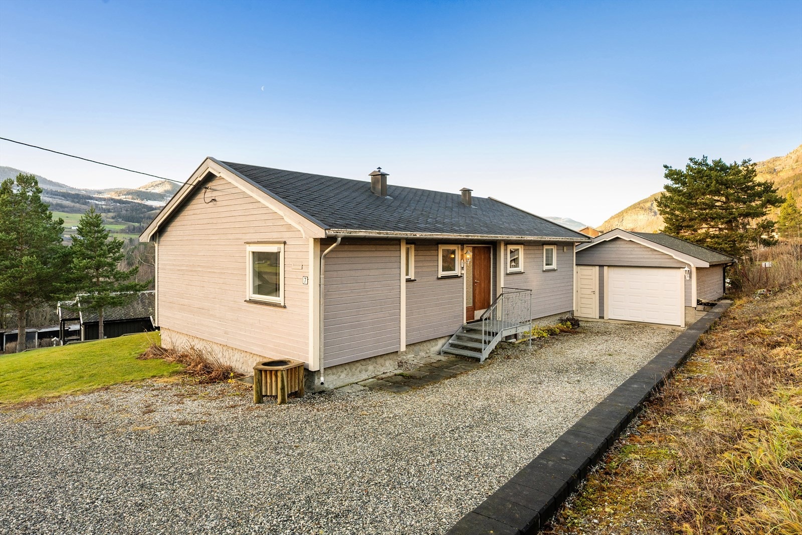 Gruset adkomst og gårdsplass, og parkering i garasje rett utenfor døra. Galleribilde