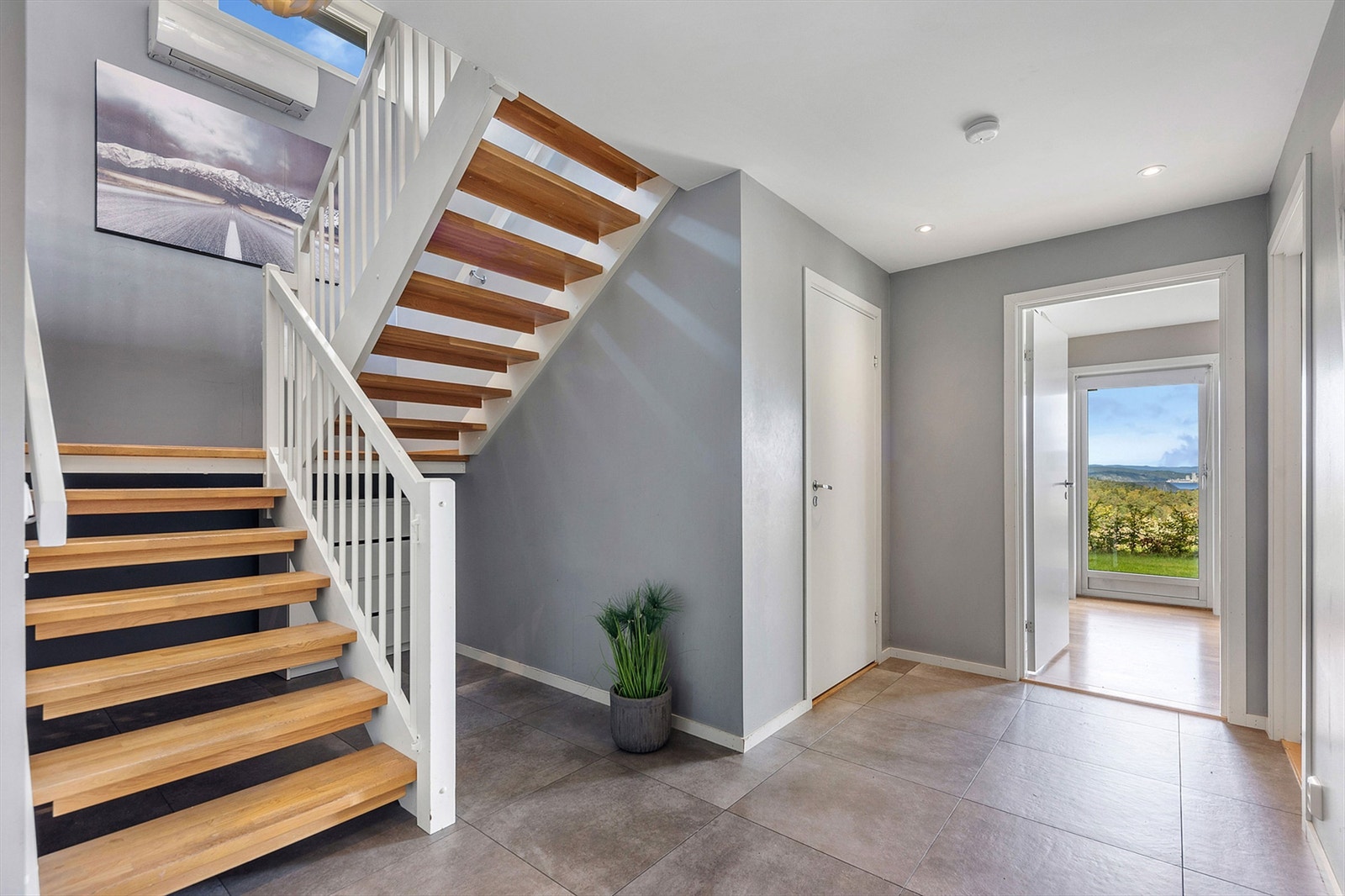 Fra hallen fører en solid svingtrapp i tre deg opp til boligens sosiale sone i andre etasje. Galleribilde