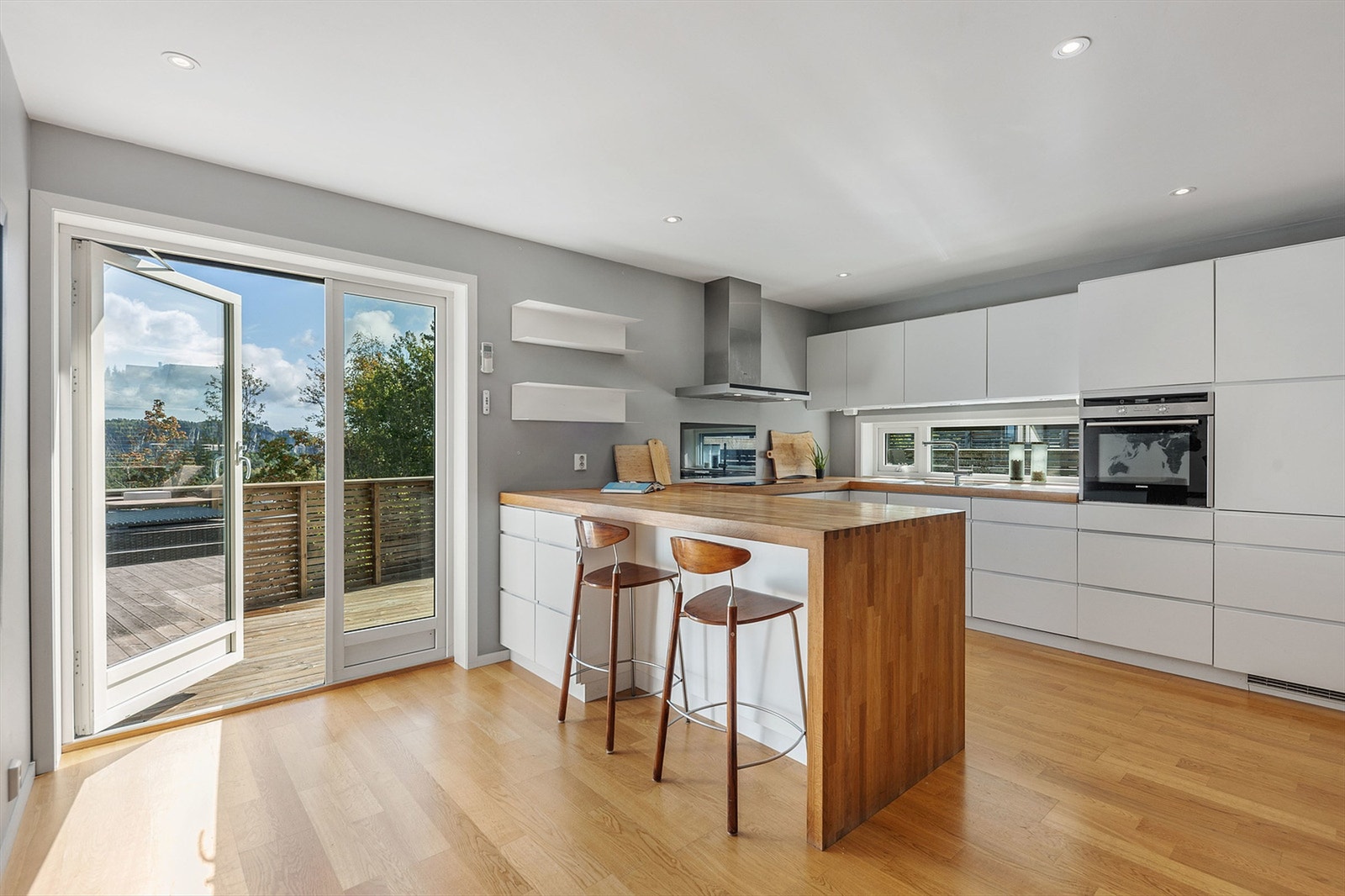 En solid benkeplate i eik og integrerte hvitevarer understreker den gjennomførte stilen, som forsterkes med den solide benkeplaten i eik. Galleribilde