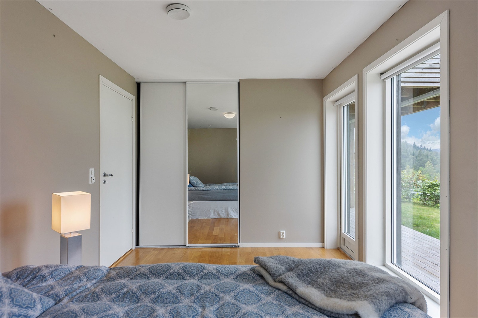 En stor skyvedørsgarderobe med speilfronter gir rikelig med oppbevaringsplass. Galleribilde