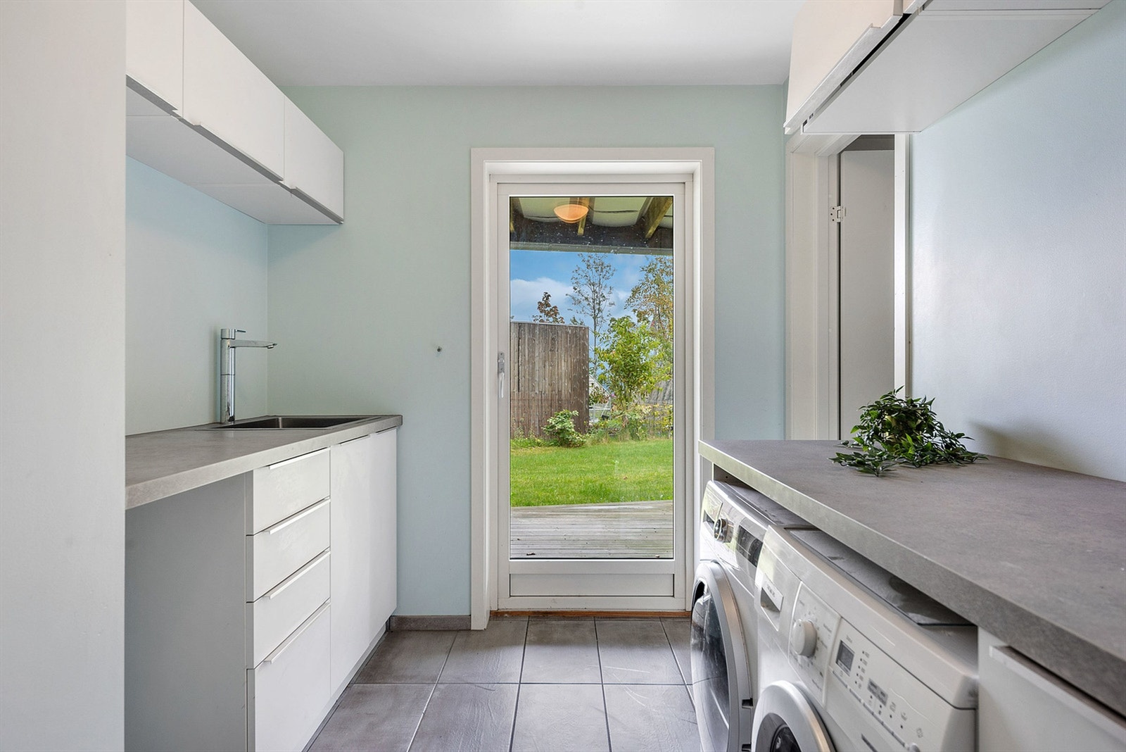 Praktisk vaskerom med egen utgang, gode arbeidsflater og opplegg for vaskemaskin og tørketrommel. Galleribilde