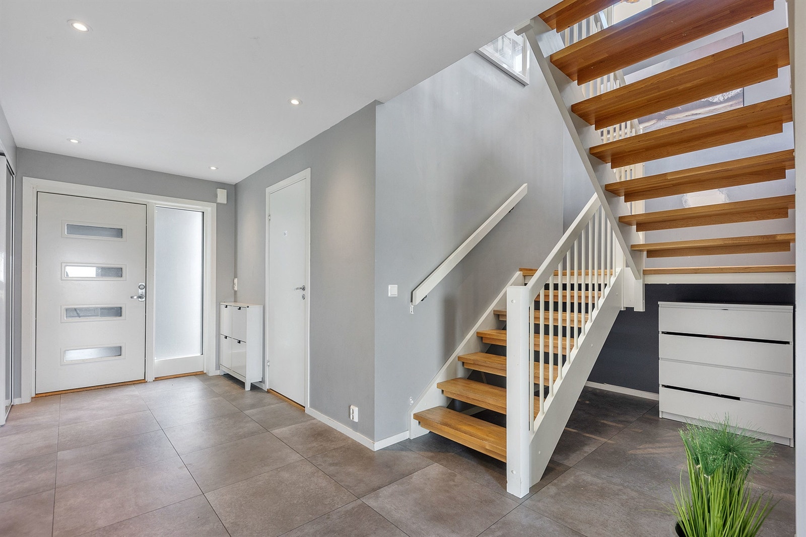 Romslig entré med flislagt gulv og god plass til oppbevaring av yttertøy. Bilder er tatt i 2023 og det vil derfor kunne være slitasje og bruksmerker som ikke fremgår av bildene. Galleribilde