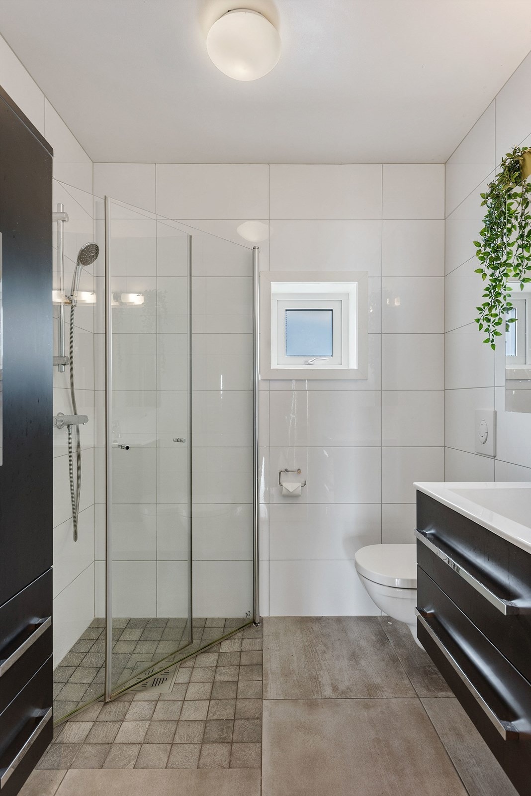 Badet i andre etasje er også flislagt og utstyrt med med servantinnredning, dusjhjørne og vegghengt wc. Galleribilde