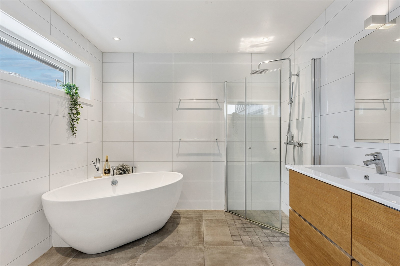 Hovedbadet i første etasje er flislagt og utstyrt med både dusjhjørne og et frittstående badekar. Galleribilde