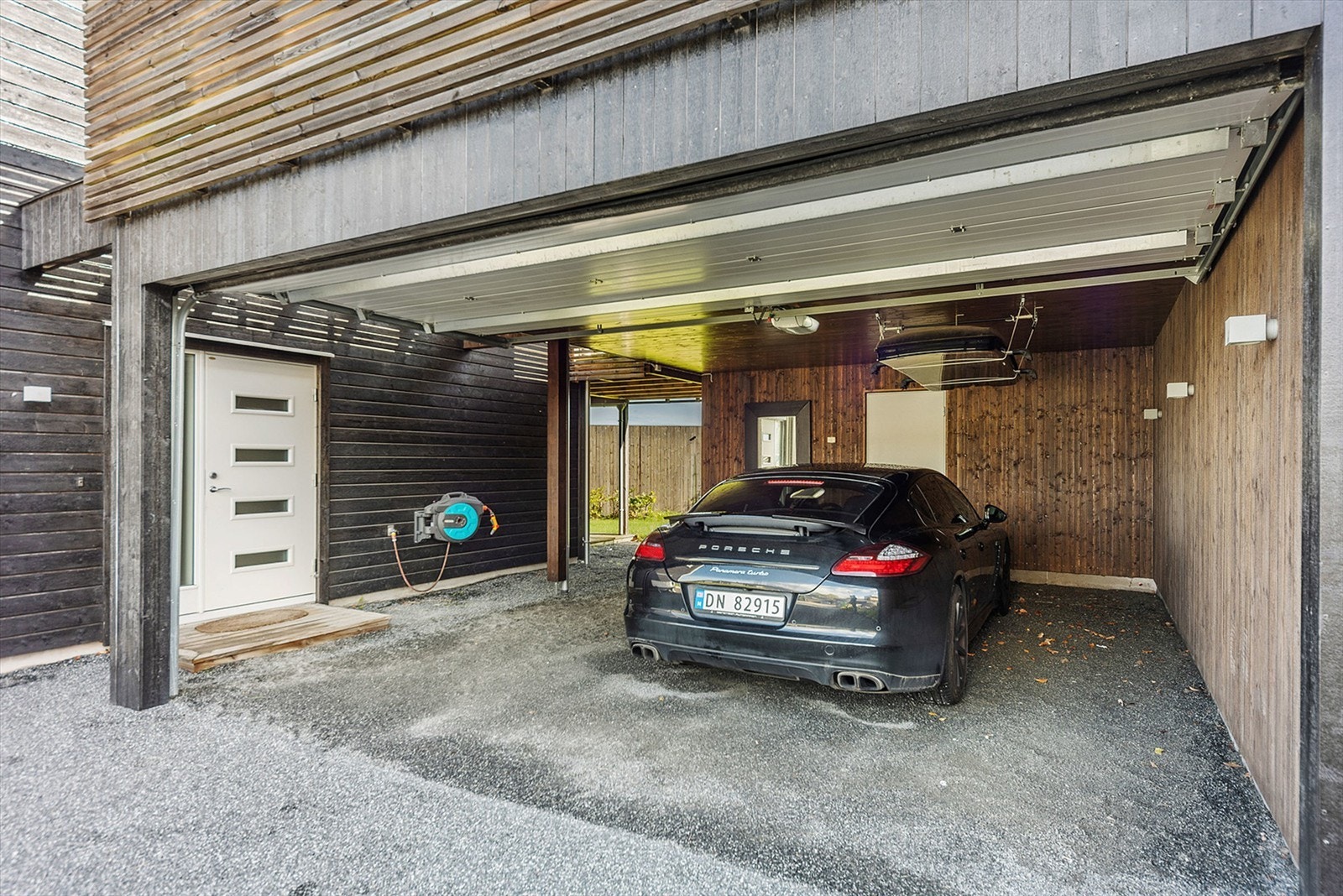 Boligen har en dobbel garasje/carport-løsning med sportsbod i bakkant. Galleribilde