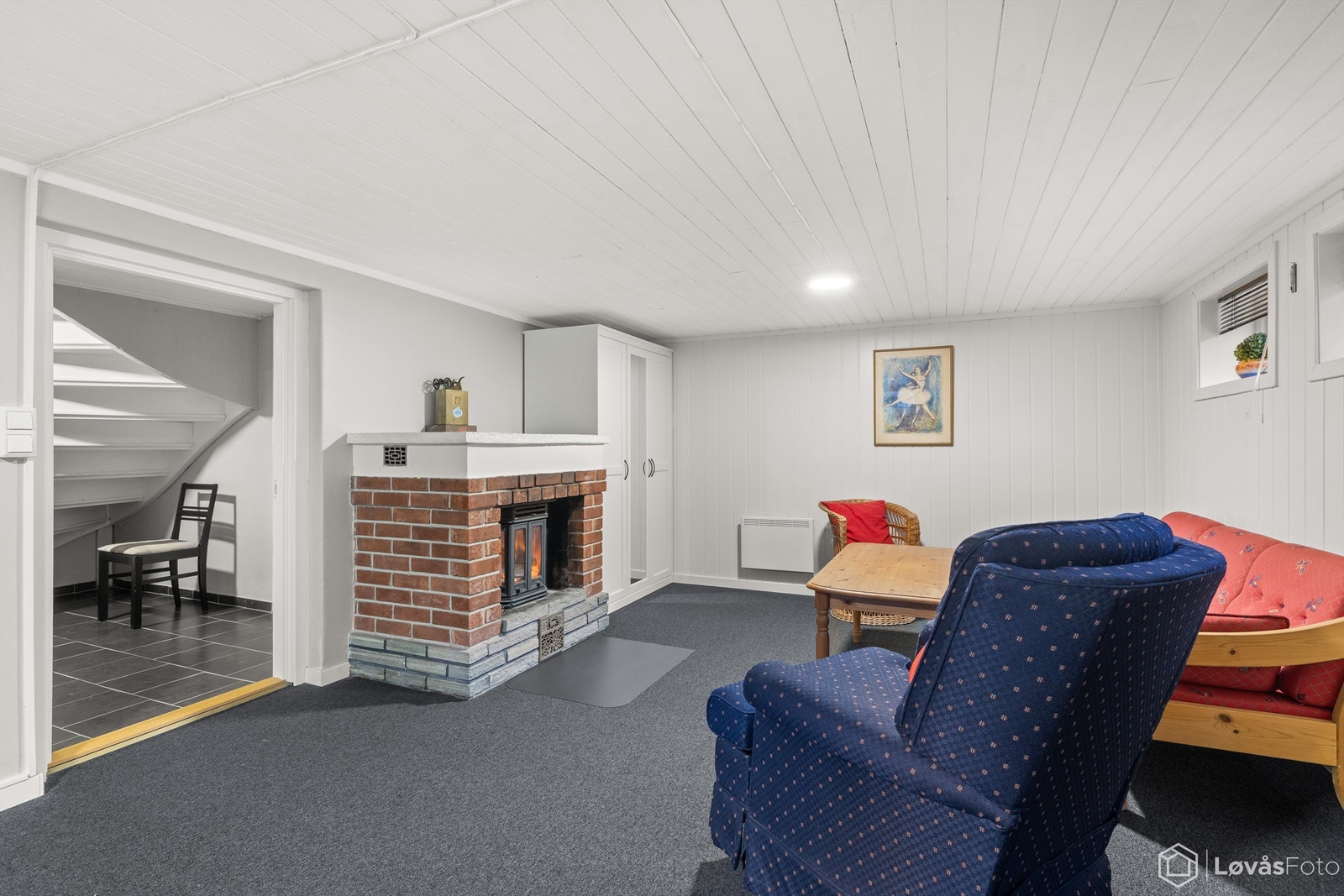 Kjellerstue av god størrelse, med mange muligheter, perfekt som ekstra stue, TV-rom, hjemmekontor eller gjesterom. Peisen skaper en lun og innbydende atmosfære. Ikke godkjent til varig opphold. Galleribilde